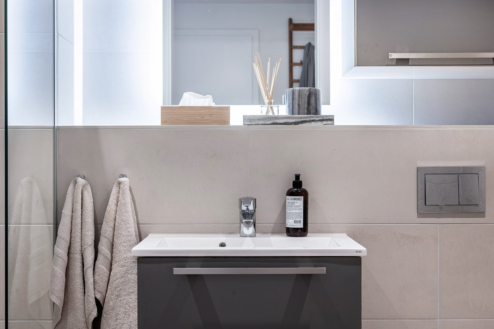 Badet har innredning fra HTH og er innredet med servantskap med ett-greps blandebatteri, vegghengt toalett med innebygget sisterne, veggskap, speil med lys, avskjermet dusjhjørne med glass, blandebatteri og dusjgarnityr. Galleribilde