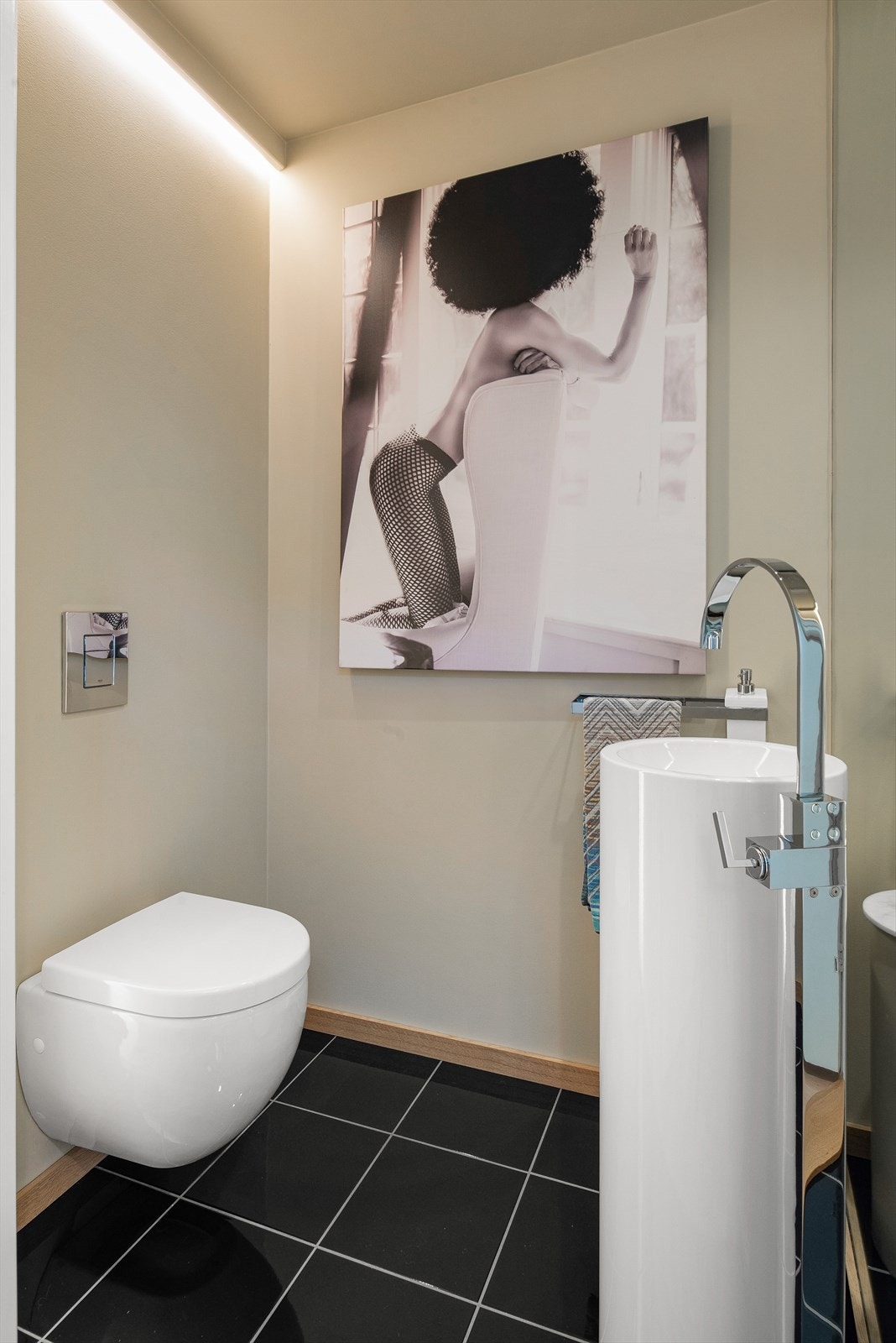 Gjeste wc har polert granitt på gulvet, designer gulvmontert blandebatteri og frittstående servant. Galleribilde