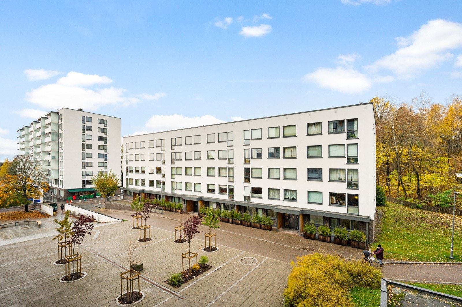 Hyggelig utsyn fra den nordvestvendte balkongen mot pent opparbeidet fellesarealer og Hovseter Torg. Galleribilde