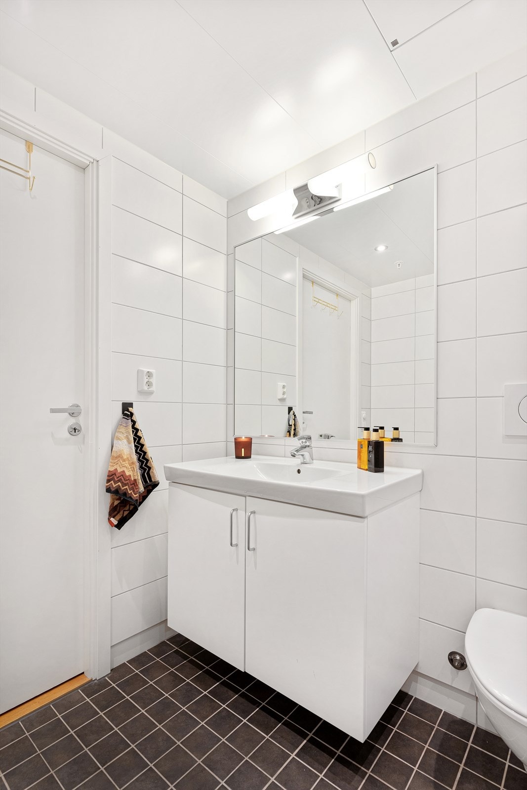 Baderommet er innredet med blant annet servantskap med heldekkende servant og vegghengt toalett med sisternekasse fra Geberit. Galleribilde