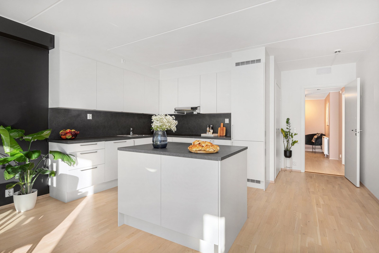 Lyst og pent kjøkken med glatte fronter, laminert benkeplate og nedfelt oppvaskkum med 1-greps blandebatteri. Galleribilde