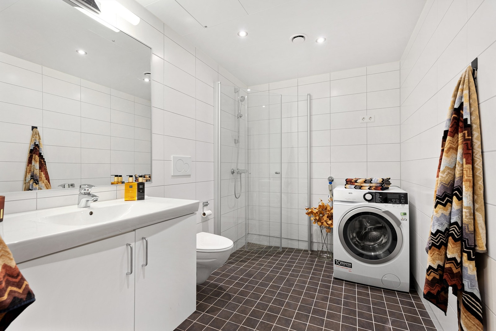 Baderommet har flislagte overflater med varme i gulv og himling med downlights. Galleribilde