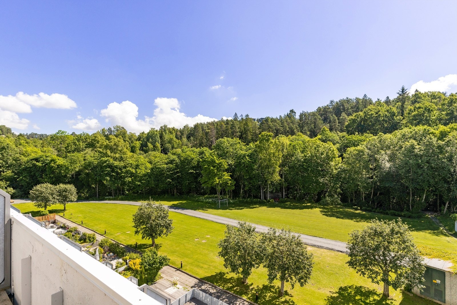 Flott utsikt over store, grønne fellesarealer mot hyggelige truområder langs Ljanselven Galleribilde