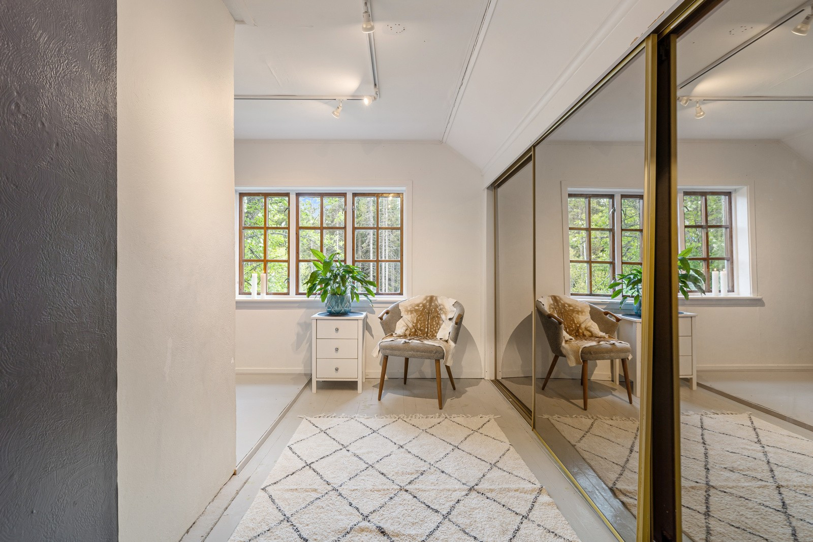 Hovedsoverommet framstår romslig og er innredet med stor skyvedørsgarderobe som gir masse lagringsplass.