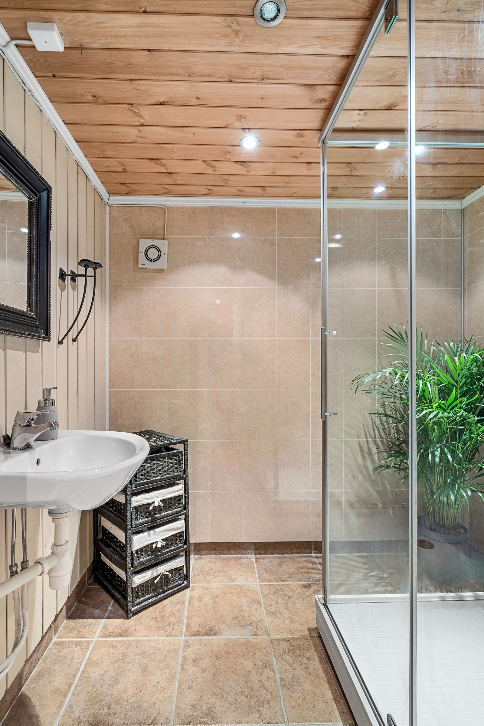 Badet i underetasjen har flisbelagt gulv med gulvvarme og dusjkabinett.