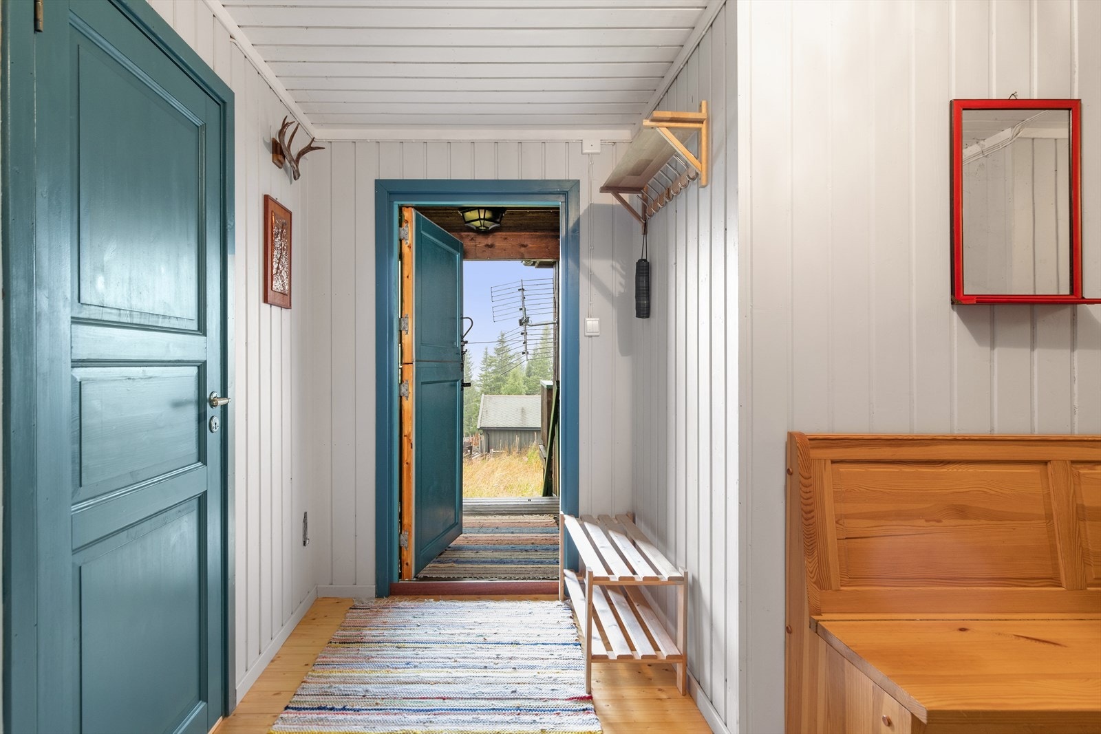 Innenfor døren blir du møtt av en innbydende entré med lysmalte panelvegger og plass for å henge fra seg yttertøy og plass for sko. Galleribilde