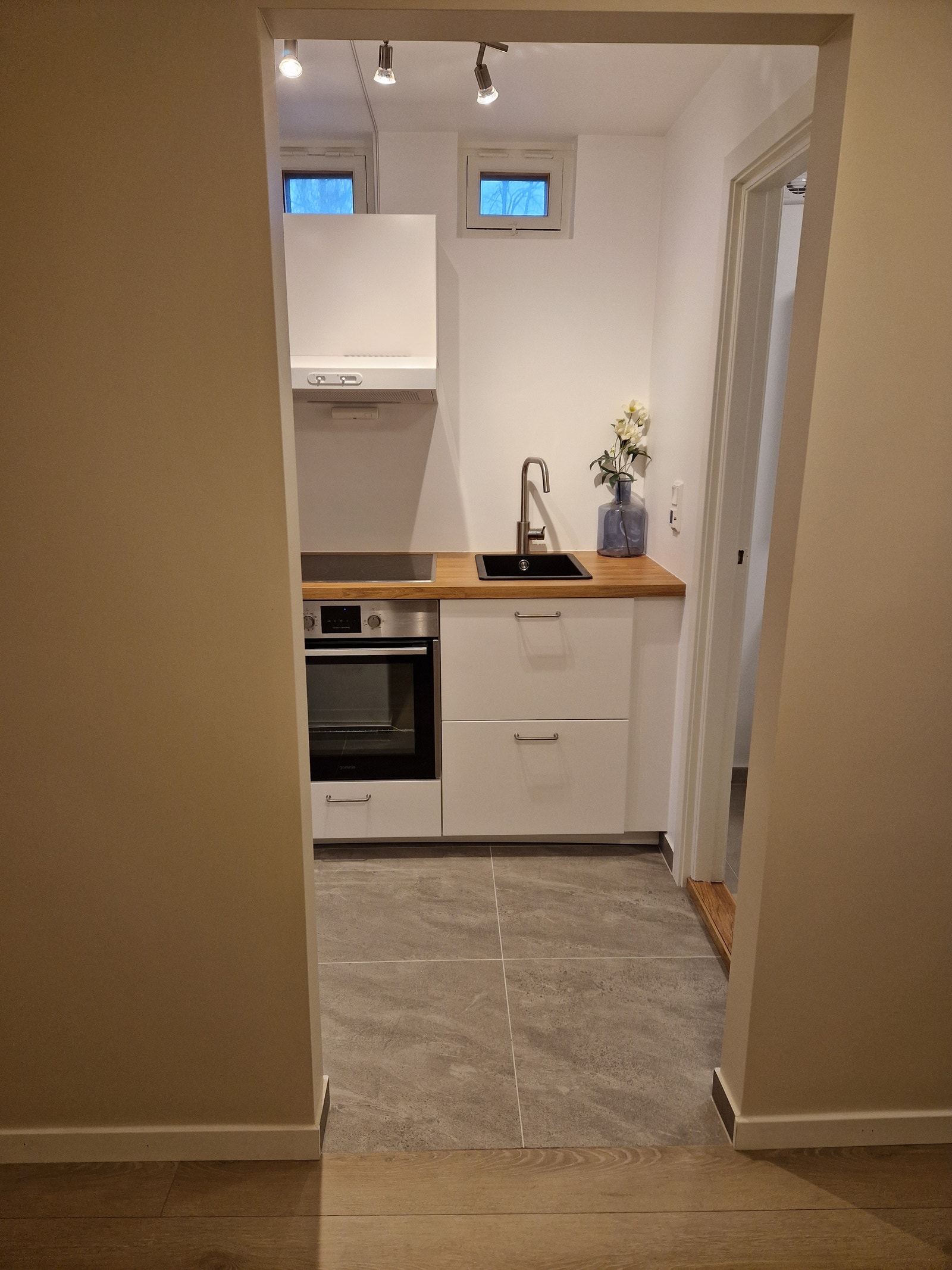 Fra gang/ rom mot flislagt kjøkken med varmekabler. Galleribilde