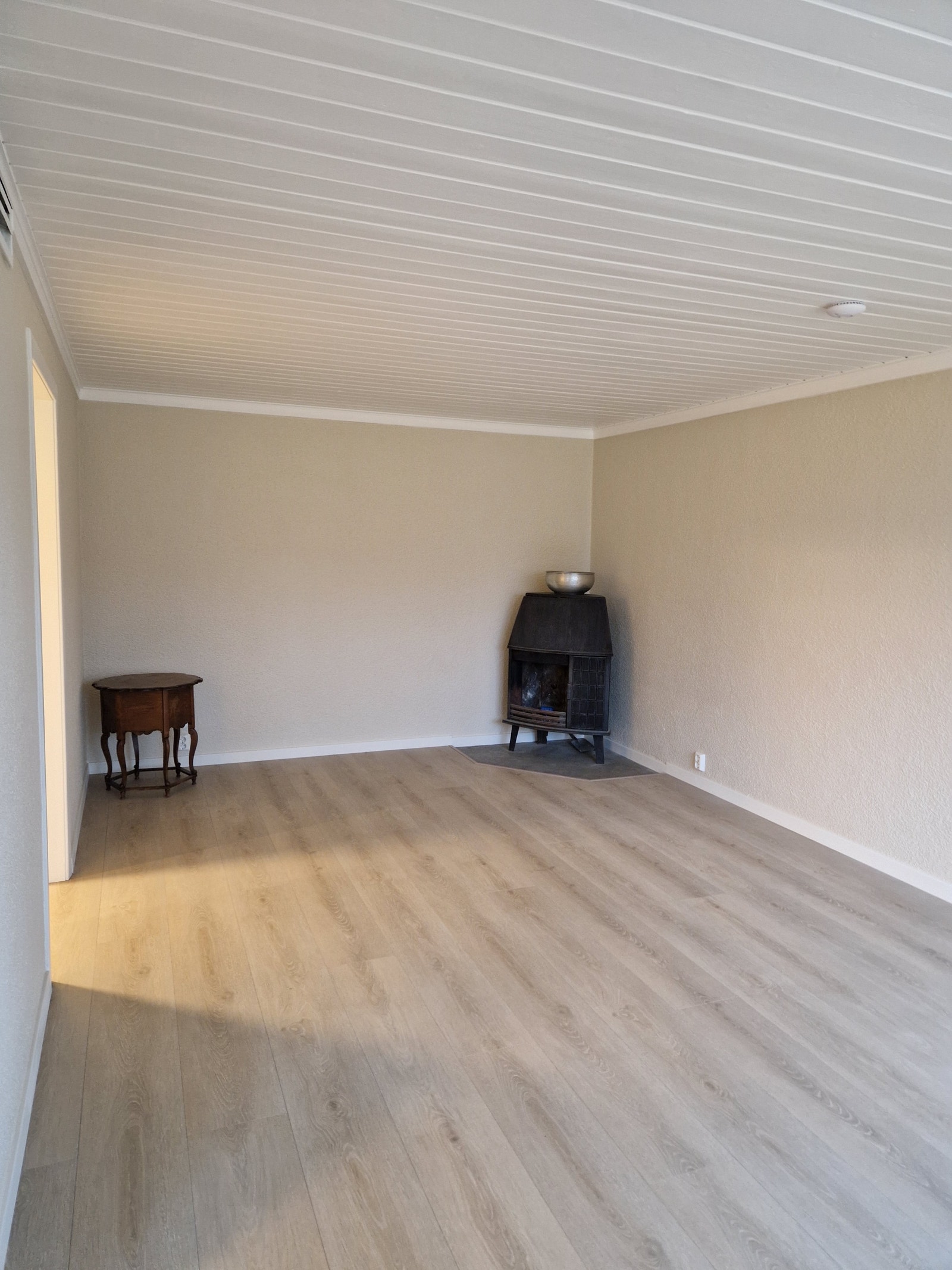 Stor stue med peis (åpen) og peisovn. Gir svært god varme om vinteren. Varmekabler i gulv. Galleribilde