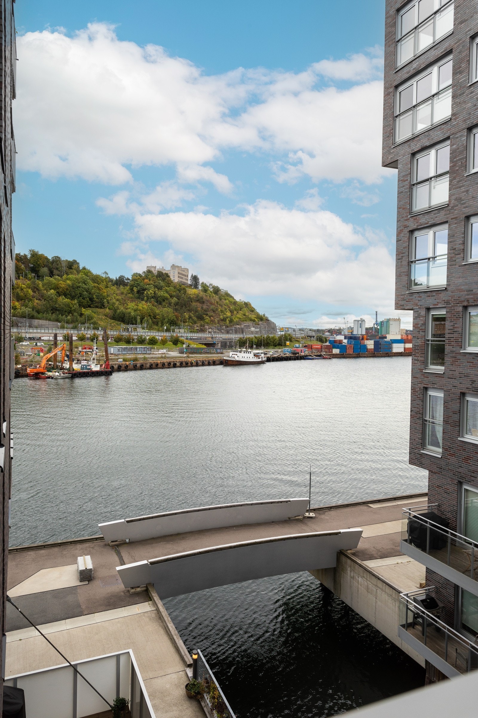 Rett under balkongen ligger båter og bryggeanlegg. Galleribilde