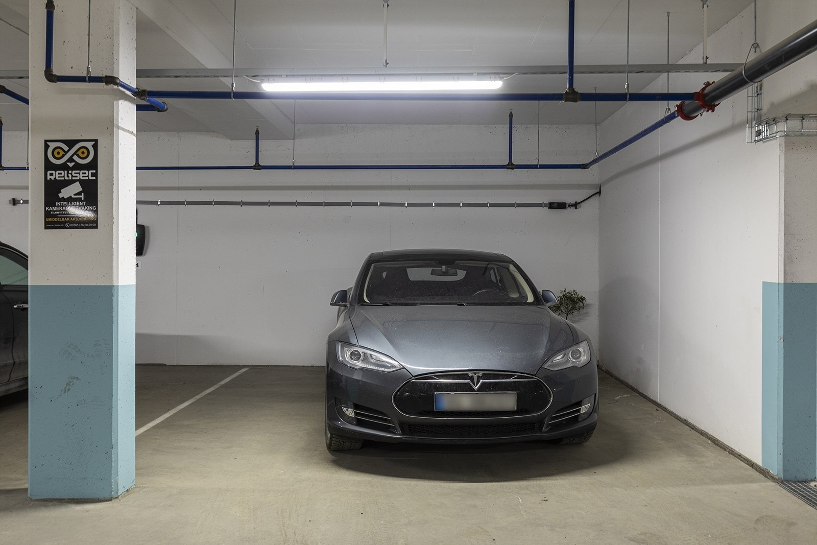 Meget romslig parkeringsplass med plass til bil og MC i kjeller medfølger. Her er det også mulighet for elbillader. Galleribilde