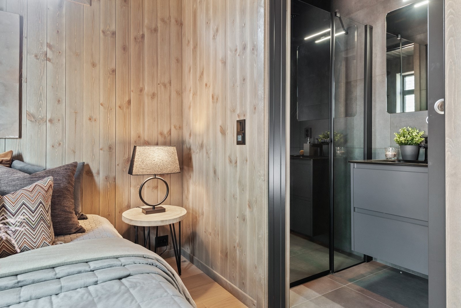 Hovedsoverommet har et eget lekkert baderom med mørke grå baderomsinnredning heldekkende svart servant med svart armatur Galleribilde