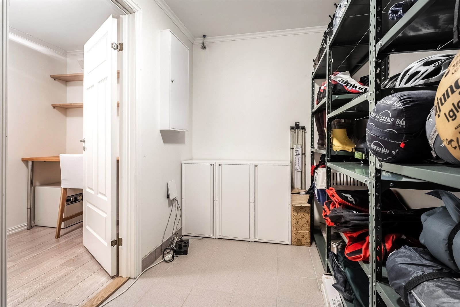 Stor lagringsbod rett innenfor hobbyrom/kontoret i u.etasjen med flislagt gulv Galleribilde