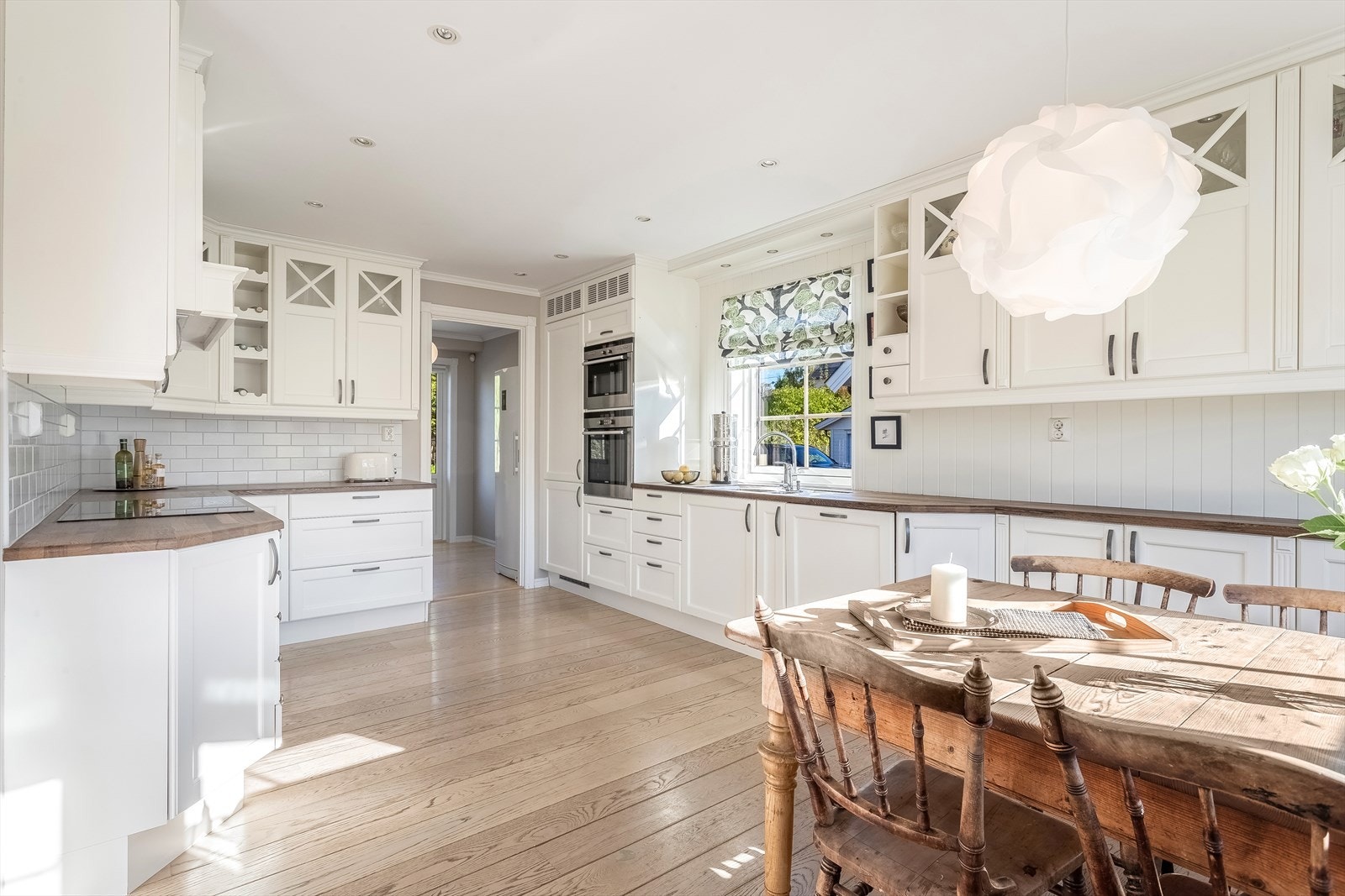 Kjøkkeninnredning med klassisk uttrykk og med mye skap -og benkeplass Galleribilde