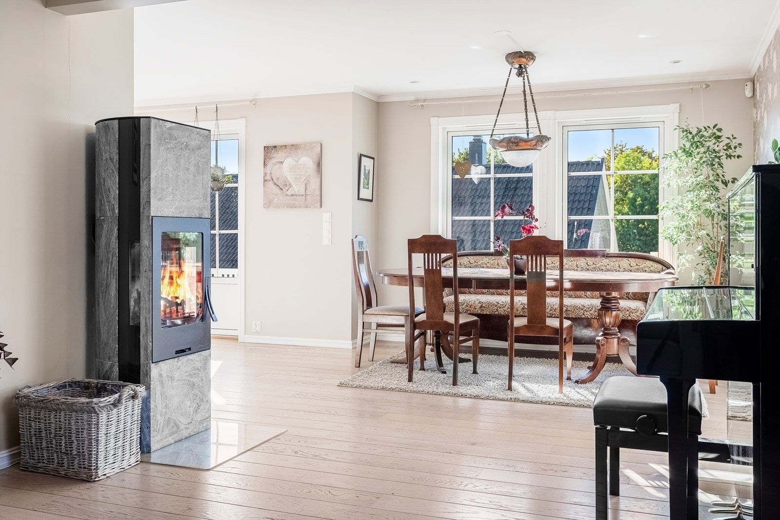 Spisemøblement er plassert mellom kjøkken og stuen i karnapp med vinduer Galleribilde