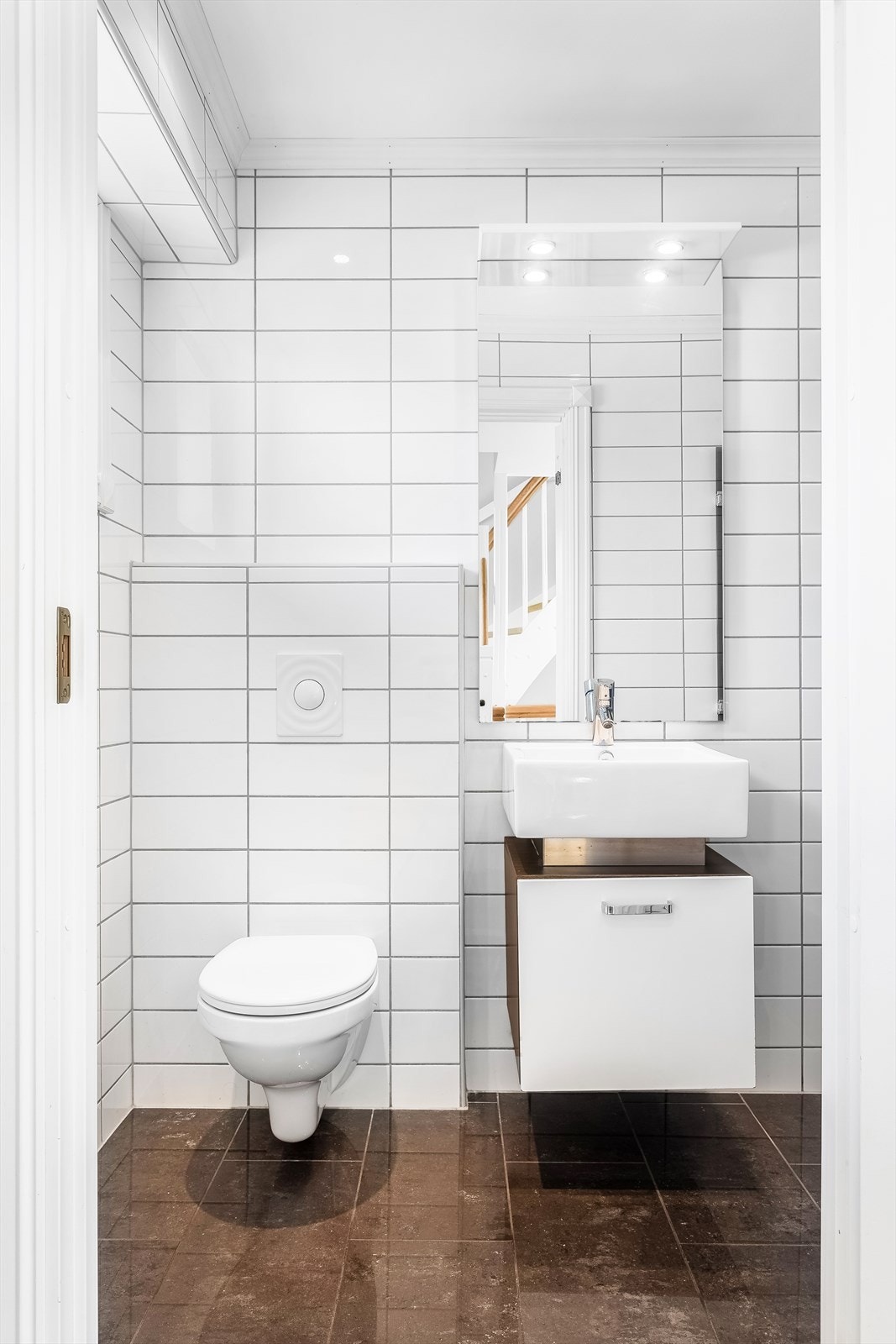 Servantskap med glatt front og speil med lys over. Tidløst fargevalg på vegger og på gulv Galleribilde