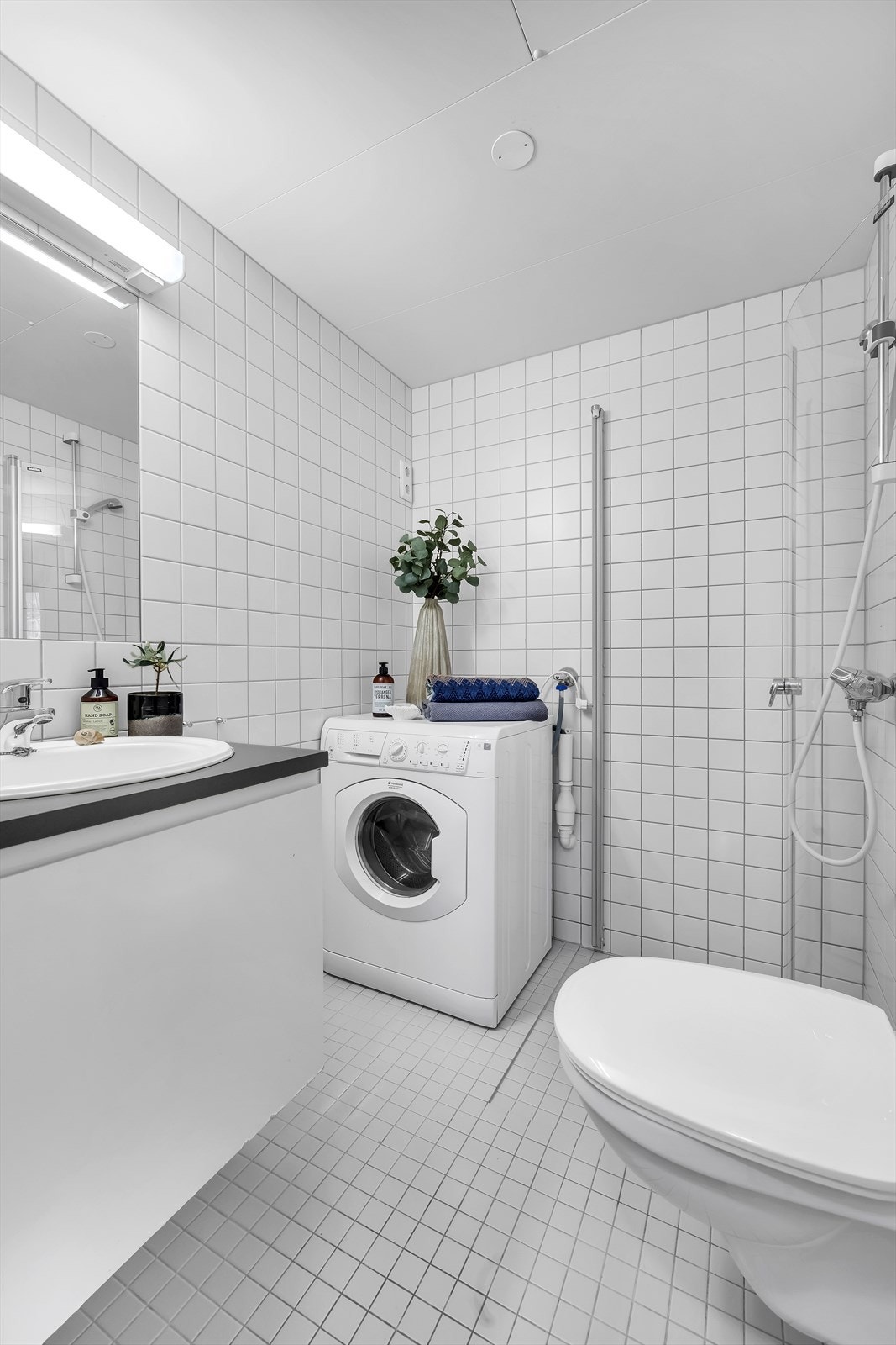 Badet er utstyrt med blant annet veggmontert wc, opplegg for vaskemaskin, dusjhjørne og innfellbare dusjdører. Galleribilde