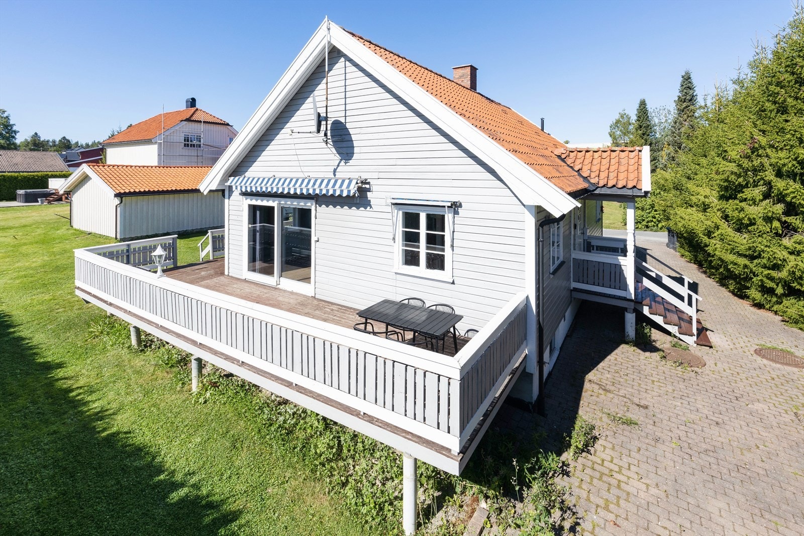 Solrik terrasse som på 2 sider av huset Galleribilde