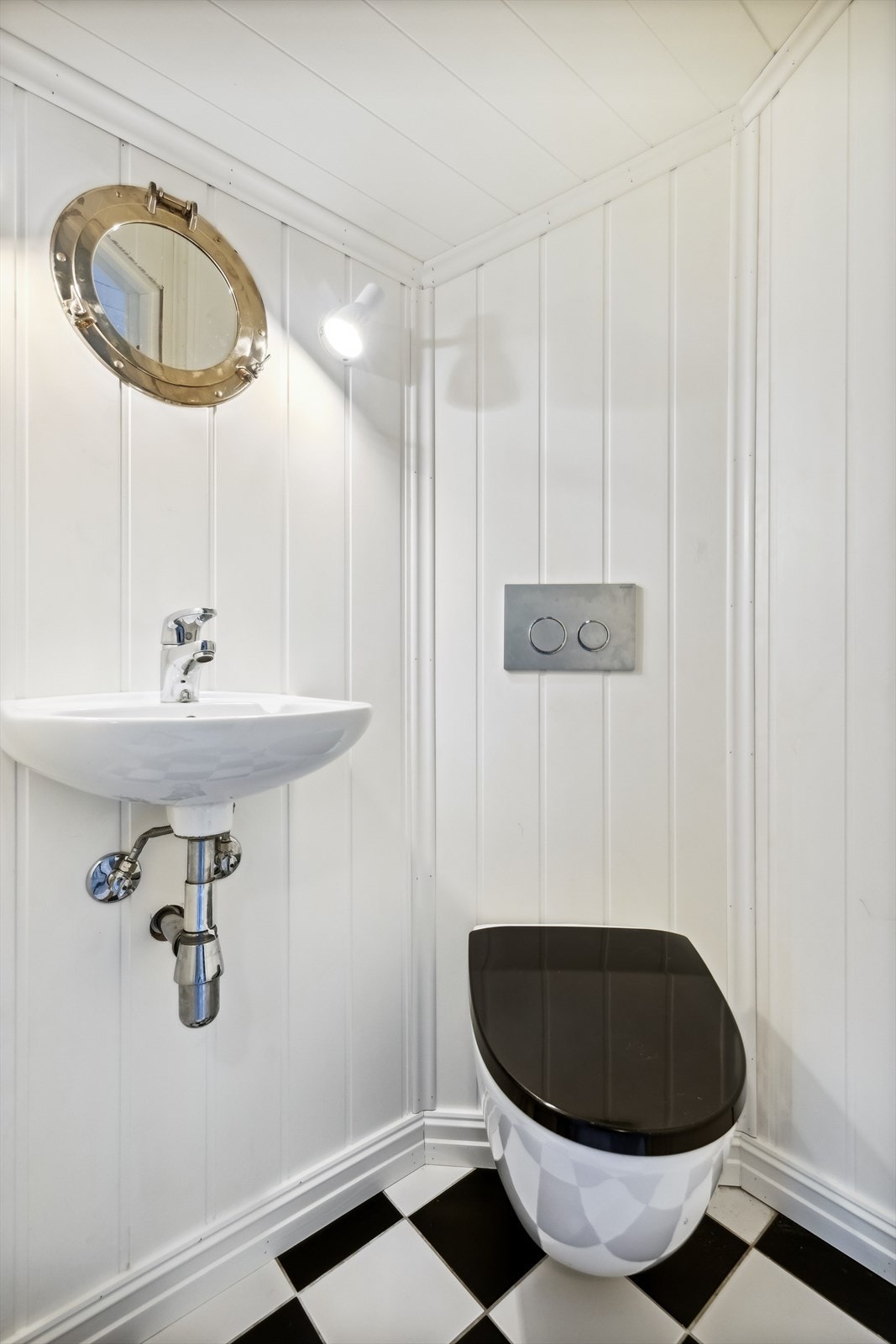Wc-rommet har flislagt gulv og er utstyrt med vegghengt toalett og servant. Galleribilde