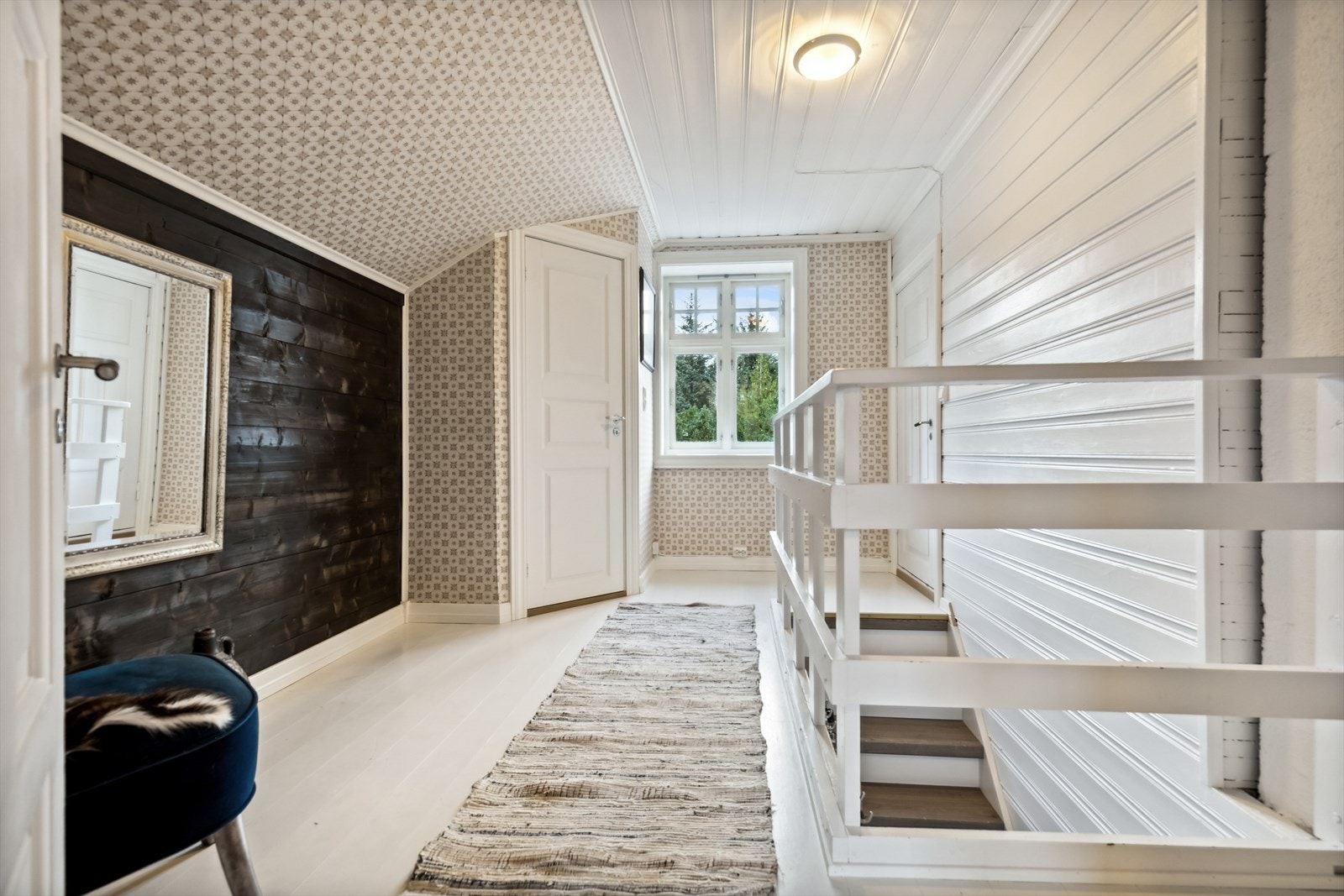 Loftsetasjen har lysmalte tregulv og vegger kledd med trepanel og tapet. Galleribilde