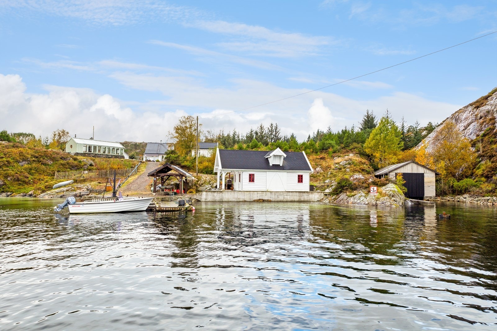 Nede ved sjøen er det opparbeidet en betongbrygge med skjørt av impregnerte trebord. Utenfor ligger en flytebrygge fra 2011 Galleribilde