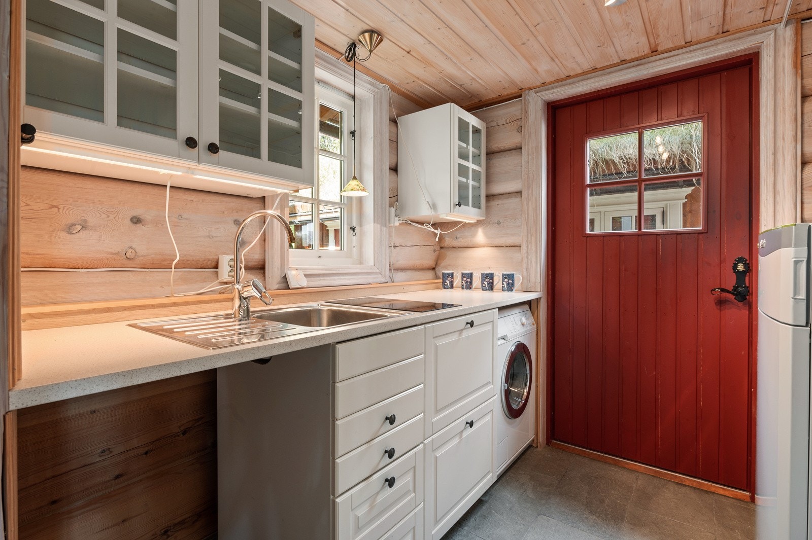 Tekjøkken/teknisk rom er plassert i hyttas nordøstlige hjørne og er innredet med vaskemaskin, oppvaskkum og benkeløsning med underskap. Galleribilde