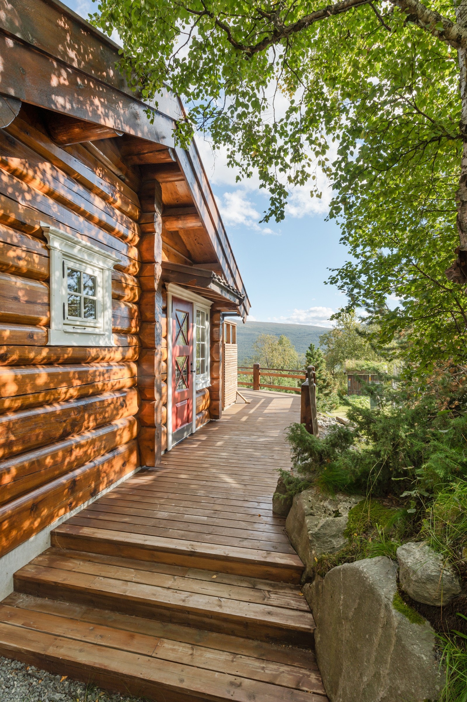 Fra kjøkkeninngangen kan man ta seg ut til terrassedel mot vest med trappeløp ned til hyttas bakside mot nord. Galleribilde