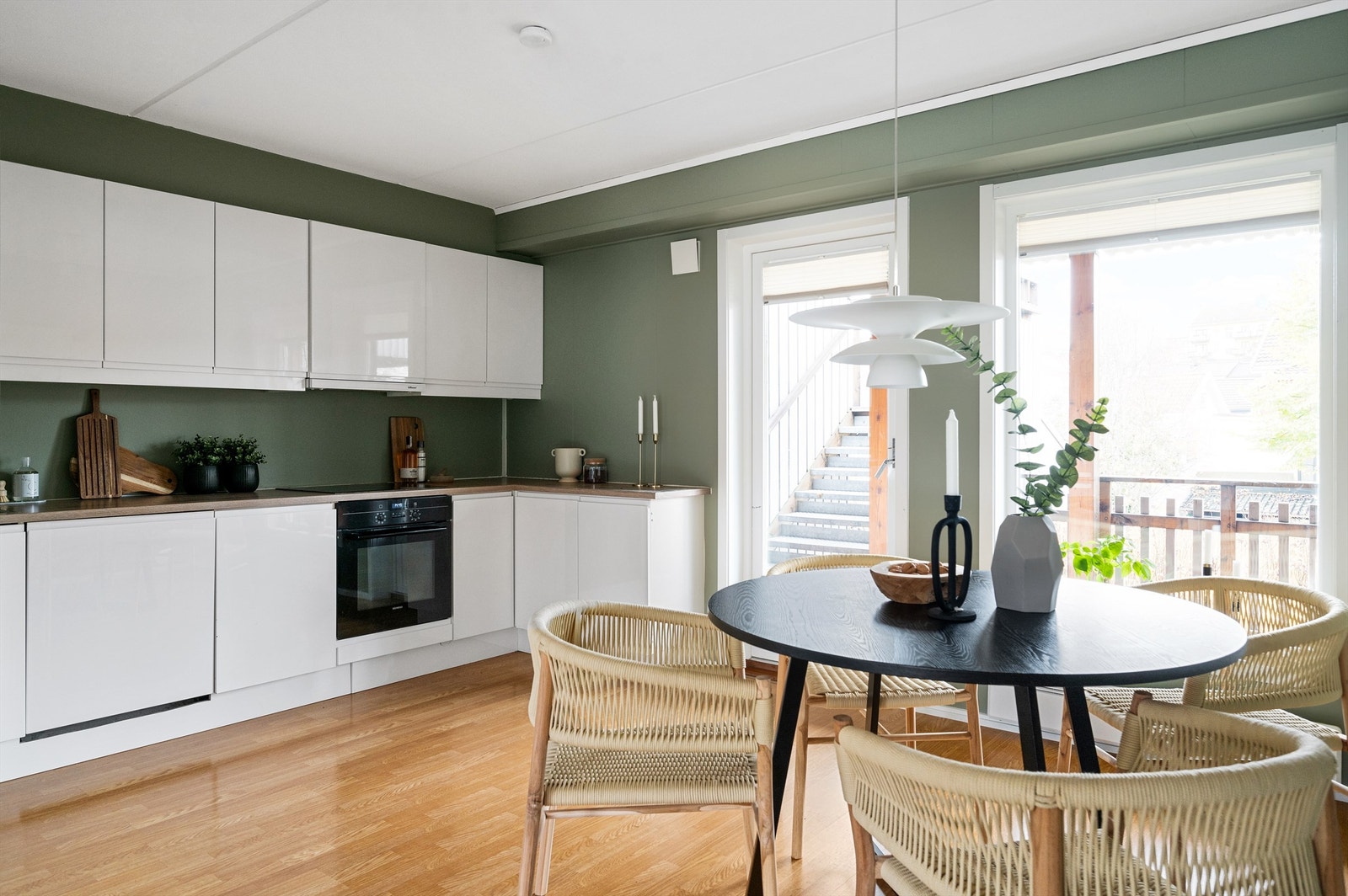 Kjøkkenet er i åpen løsning med stuen, men oppleves likevel noe tilbaketrukket. Utgang til svalgang/veranda fra kjøkkenet Galleribilde