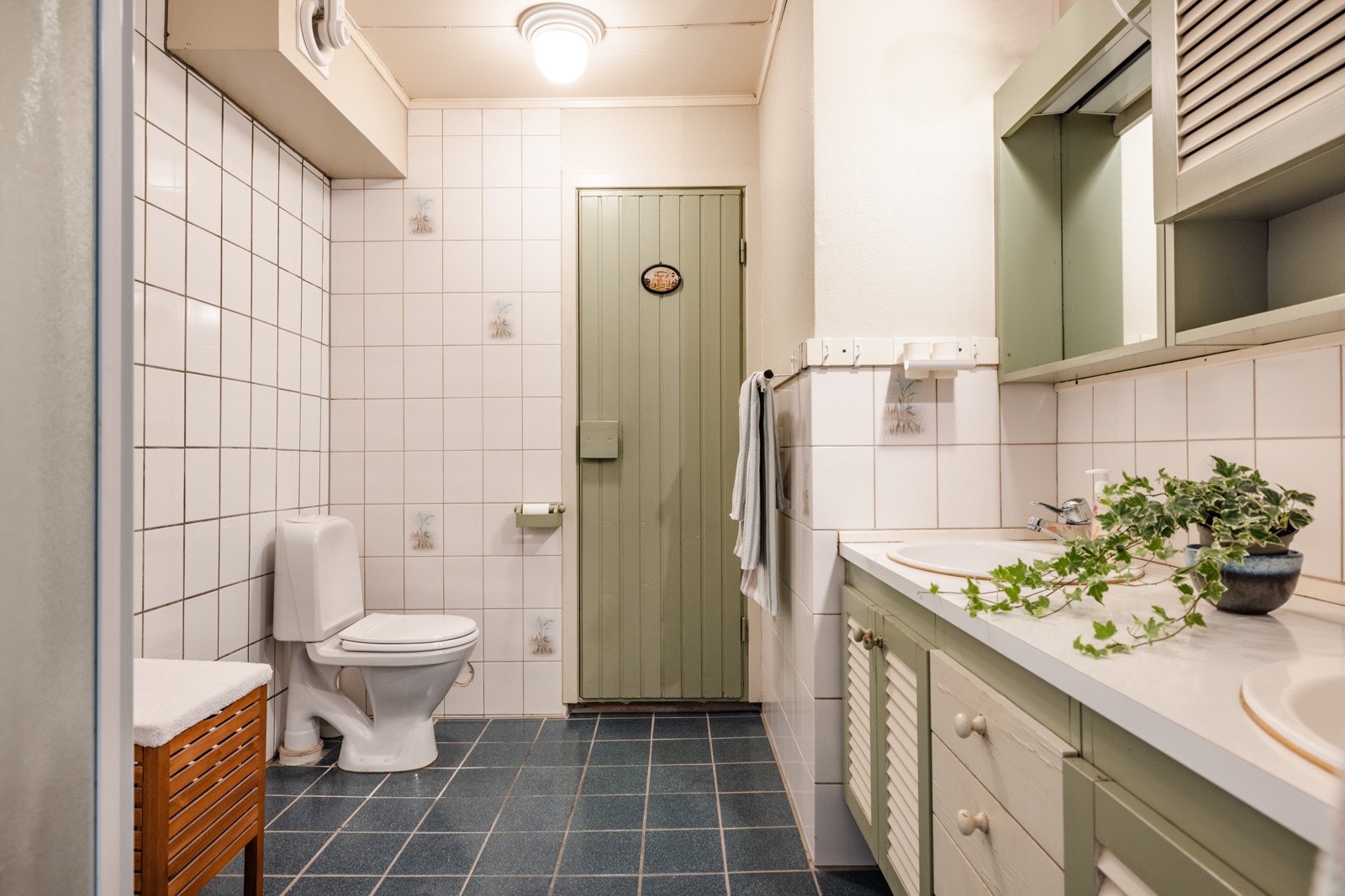 Badet er romslig og flislagt (flis på flis) med varmekabler under. Badet er innredet med toalett, dobbelservant med skap under og dusjhjørne. Galleribilde