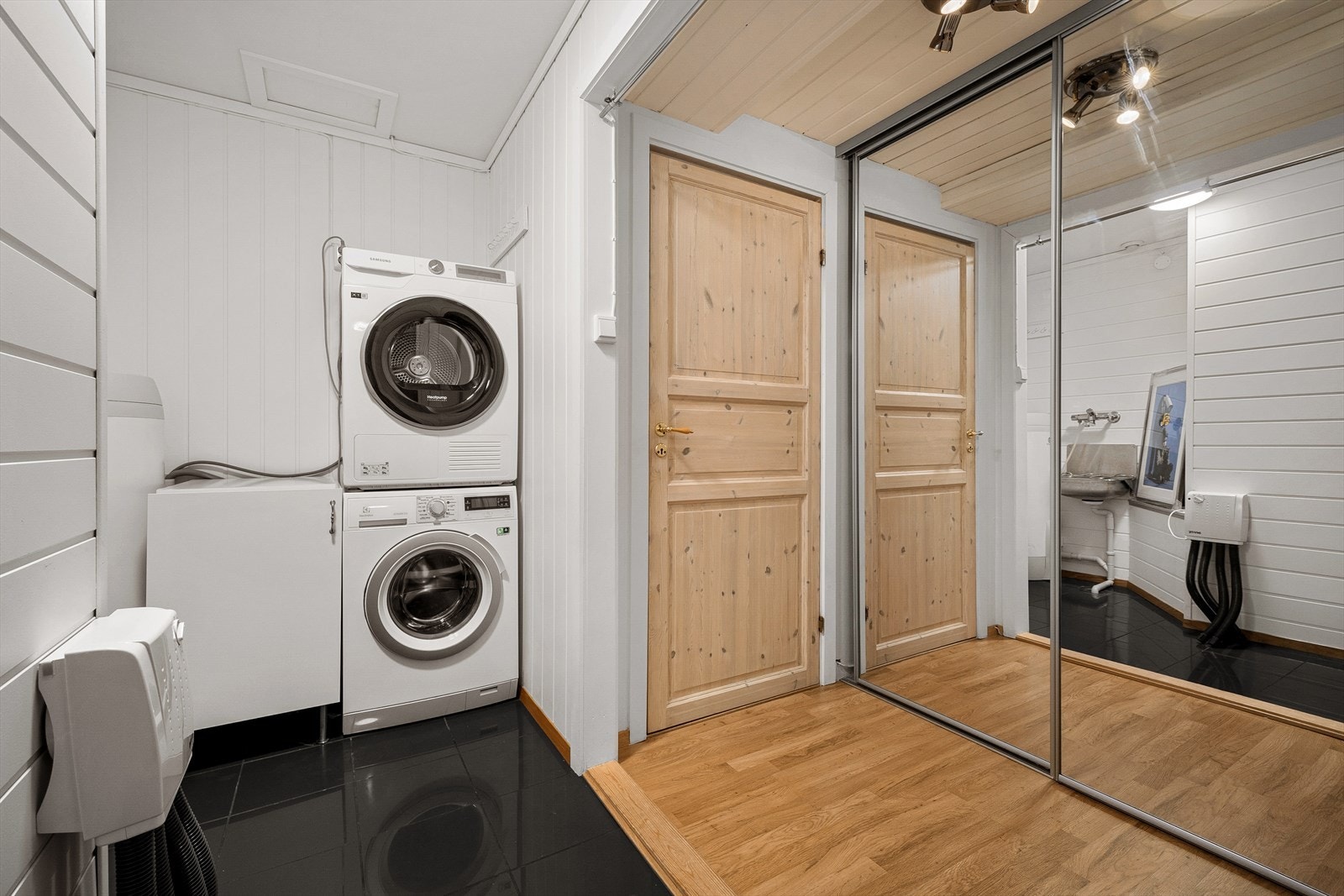 Praktisk vaskerom med stor skyvedørsgarderobe og tilgang til innvendig bod Galleribilde