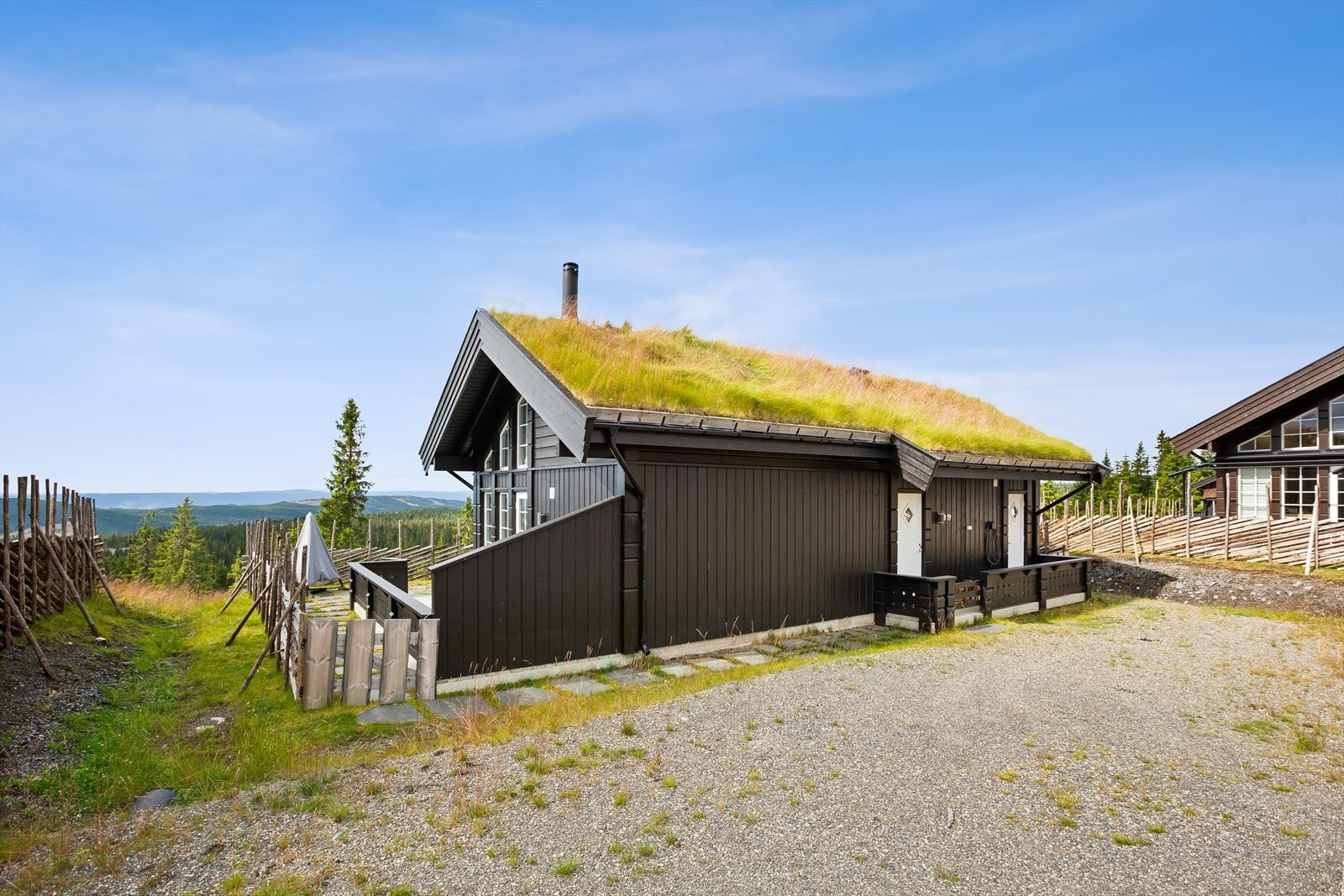 Fra gruset gårdsplass tar du deg til overbygget inngangsparti med belysning. Galleribilde