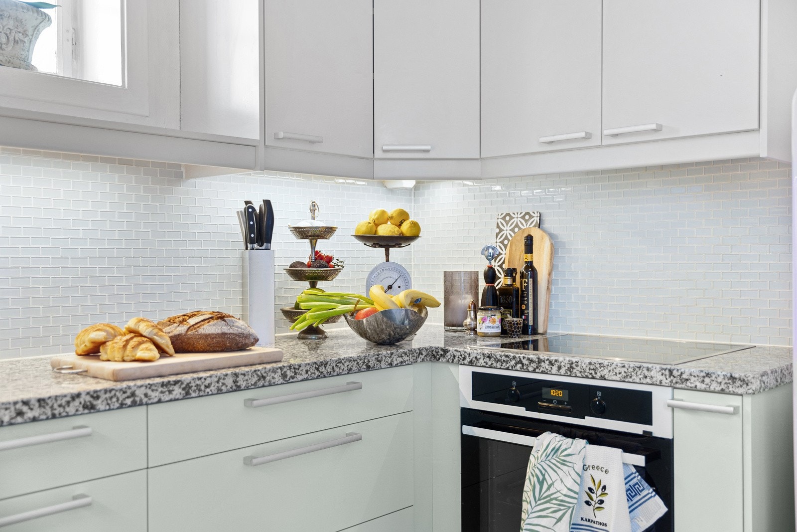 Kjøkkenet er utstyrt med granitt benkeplate, mosaikk fliser over benk, underlimt kum, integrert komfyr, platetopp og oppvaskmaskin. Galleribilde