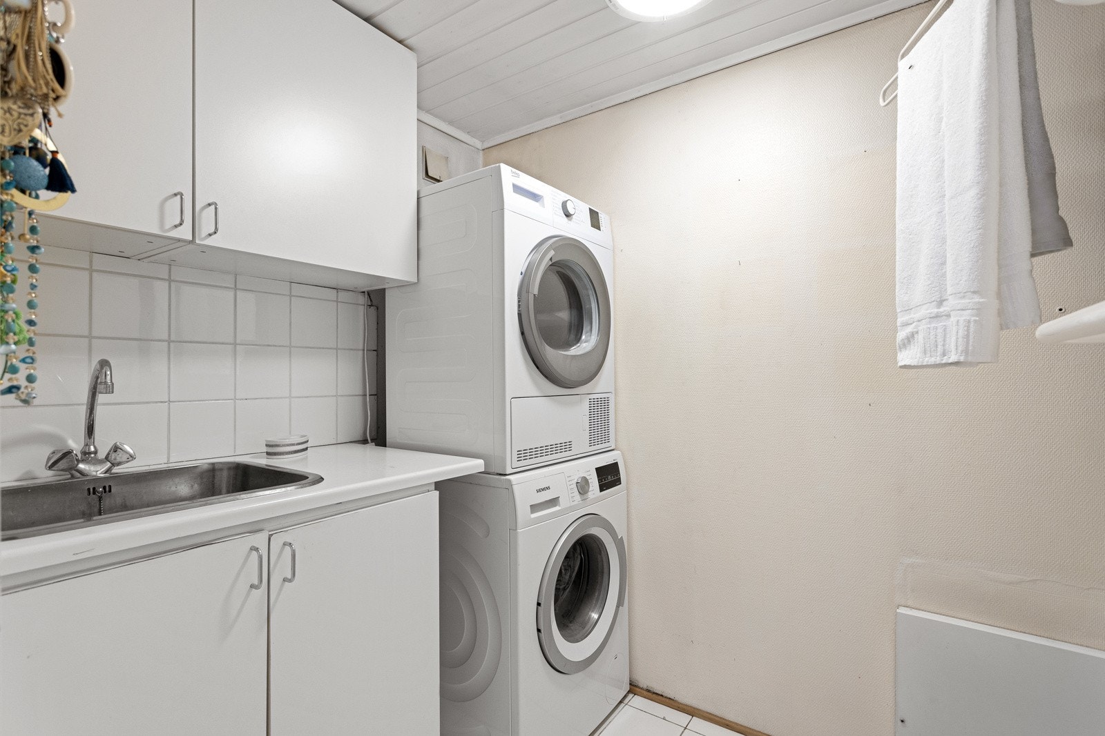 Det er opplegg for vaskemaskin og tørketrommel samt utslagskum i laminat innredning. Galleribilde