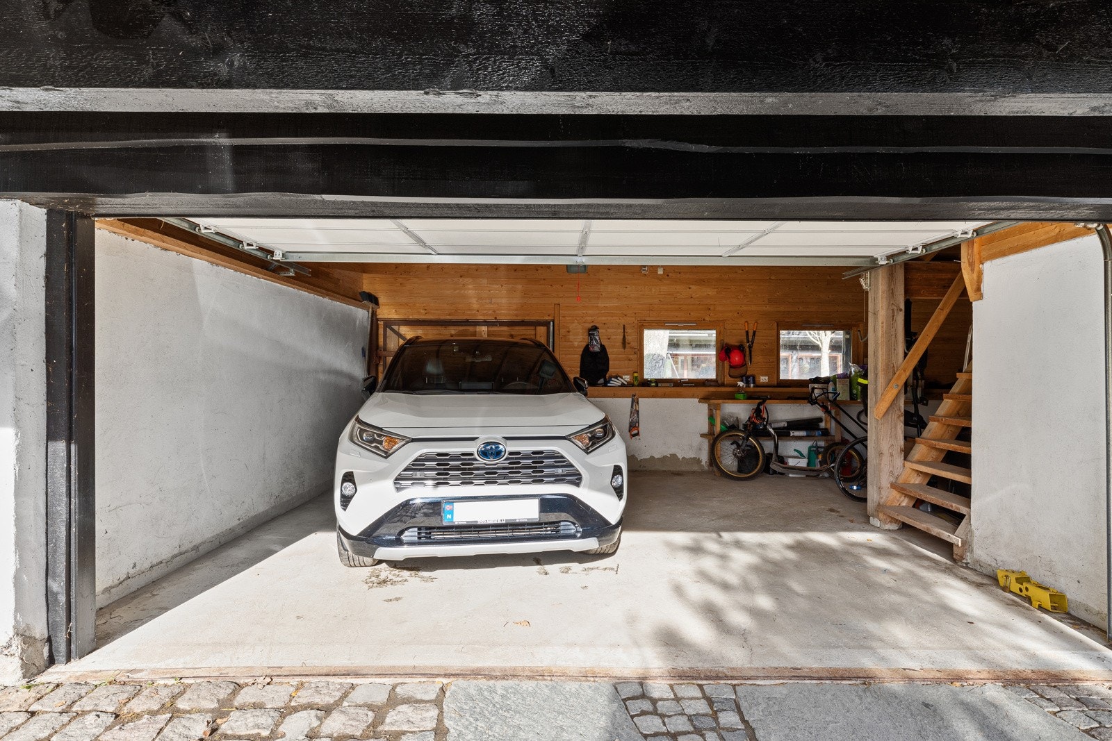 Det er 2 doble garasjer og masse lagerplass. Vegg i bakkant kan åpnes, med mulighet for gjennomkjøring til lukket atrium. På siden av garasjen er det et verksted/lager, med stalldør dersom man trenger et sted til hesten. Galleribilde