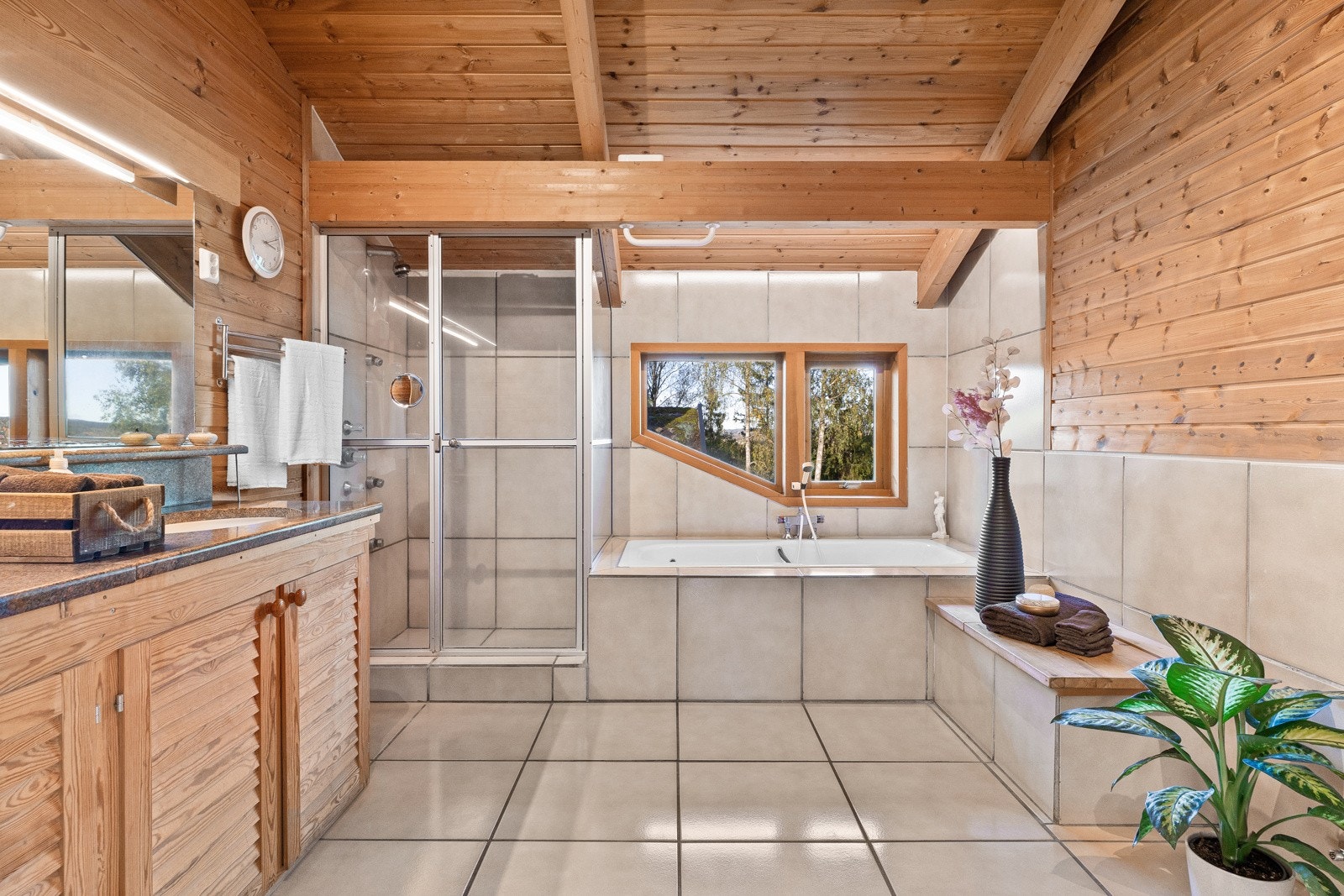 Romslig en suite bad med dusj, badekar og skittentøyssjakt direkte til vaskerommet Galleribilde