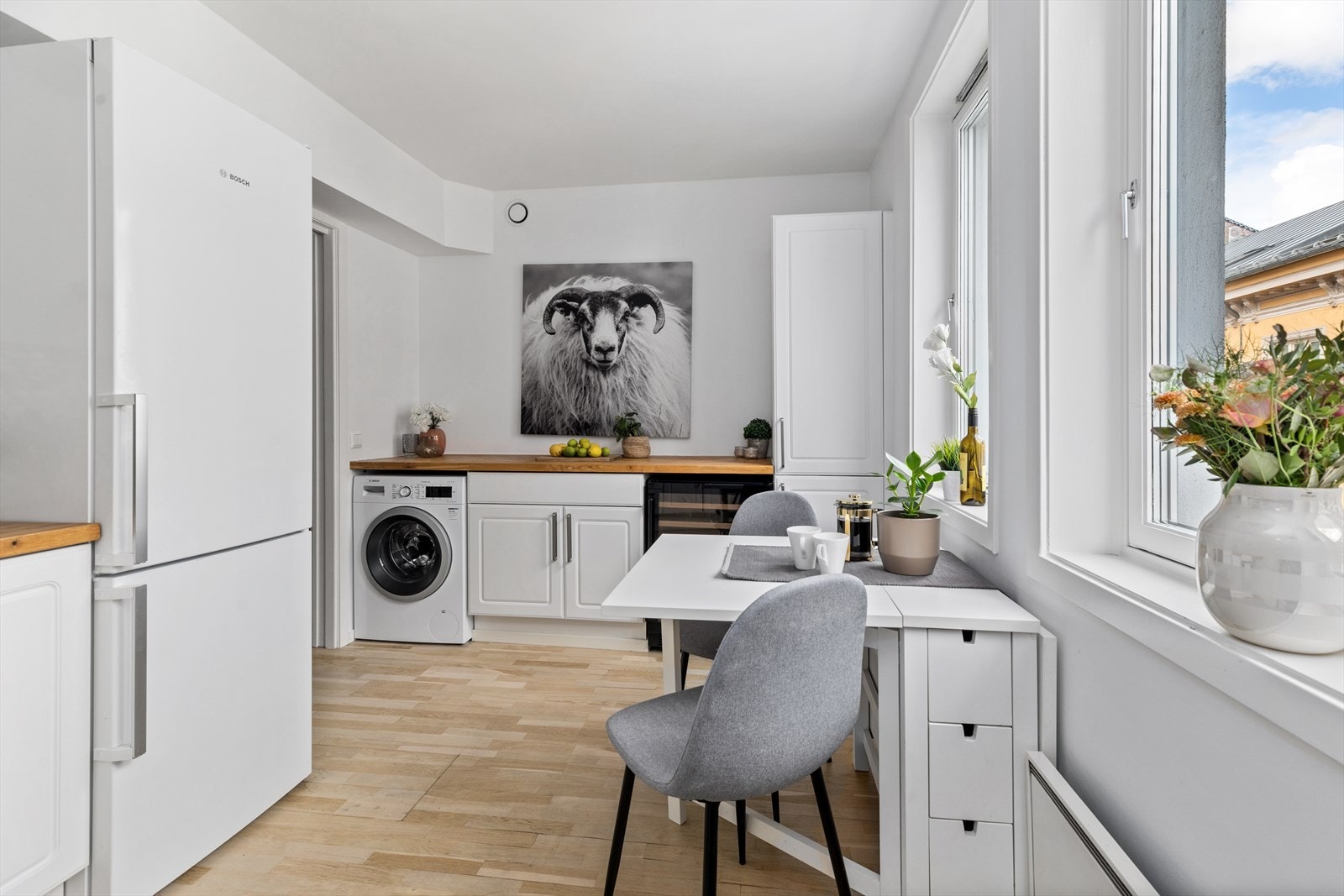 Kjøkkeninnredningen består av hvite profilerte fronter med heltre eik benkeplate, dobbel oppvaskkum, samt frittstående hvitevarer som komfyr, kjøl- /fryseskap, oppvaskmaskin, vinskap og vaskemaskin. Galleribilde