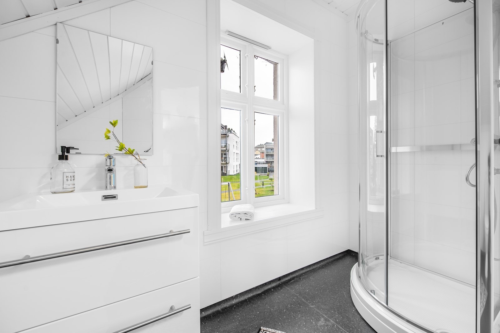 Baderommet er pusset opp. Det er overflater av baderomsplater på vegg og belegg på gulv. Galleribilde