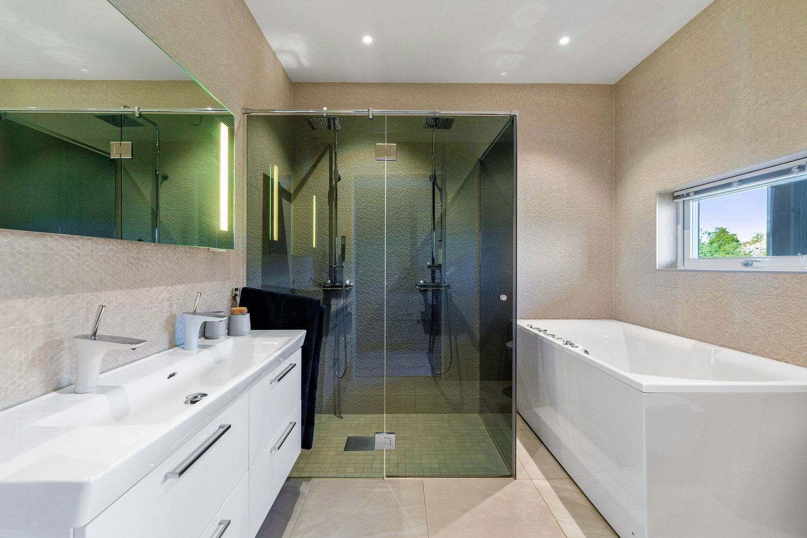 Baderom med både badekar og dobbelt sett med dusjer Galleribilde