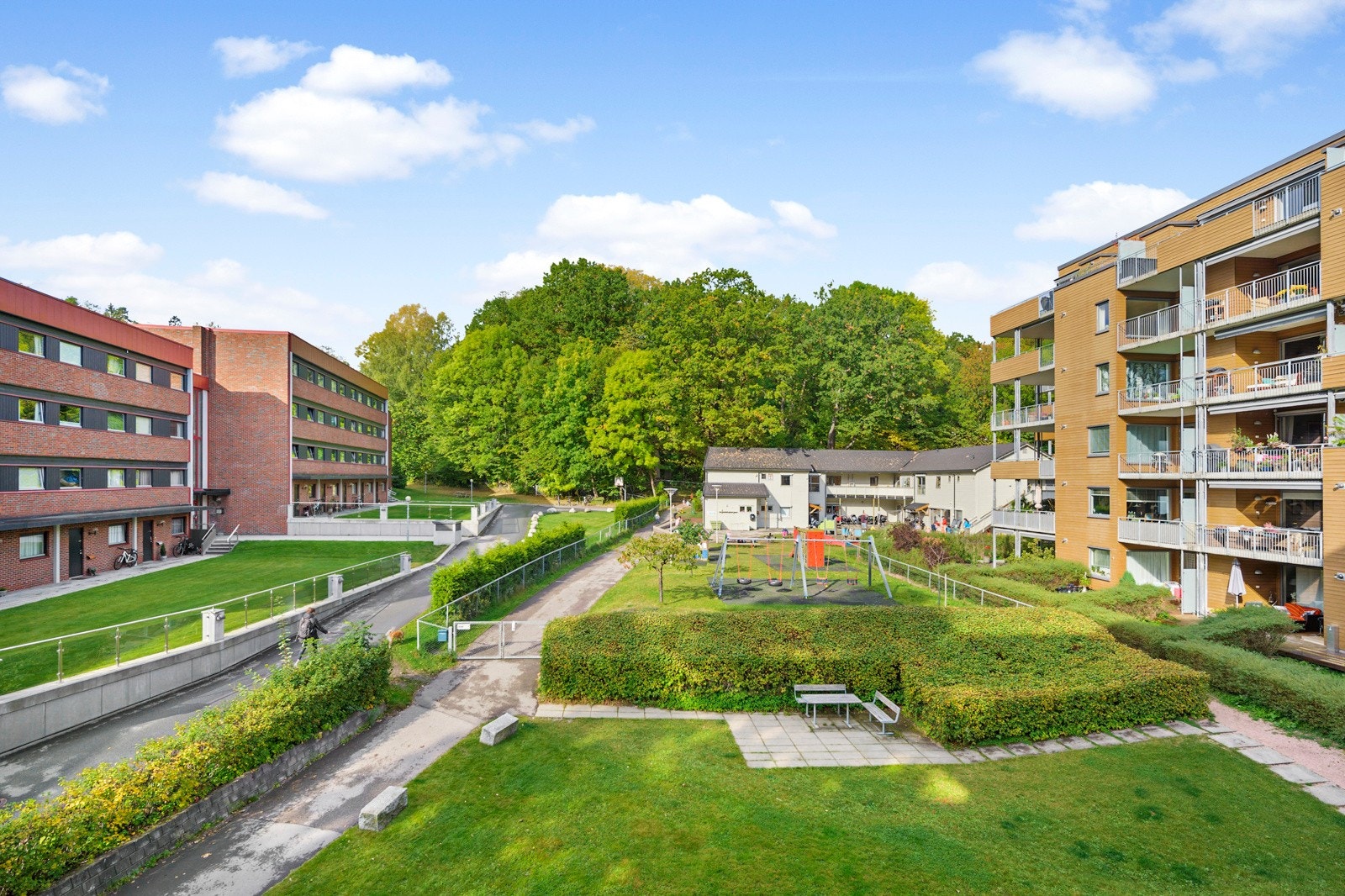 Fellesområder opparbeidet med plenarealer, trær, prydbusker, diverse beplantning og sittegrupper. Galleribilde