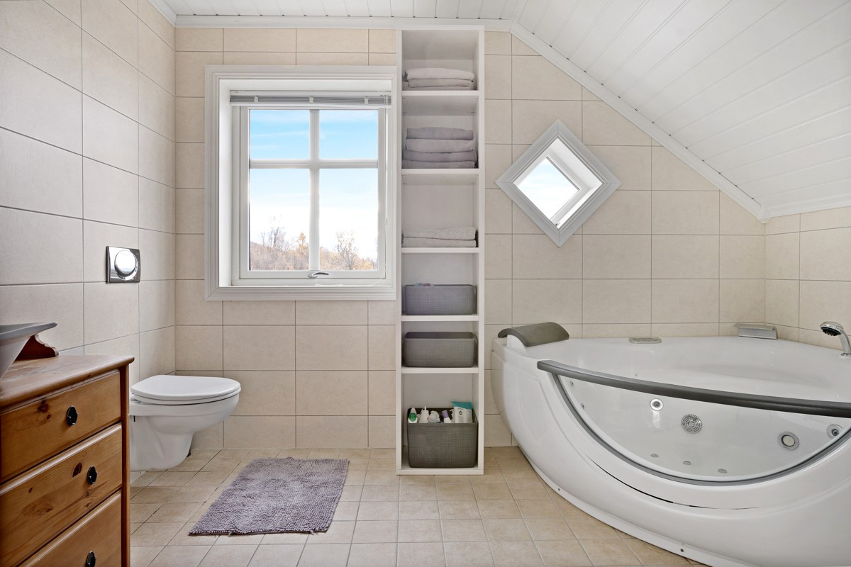 Badet i 2.etasje er utstyrt med dusjnisje, vegghengt toalett, badekar og servant