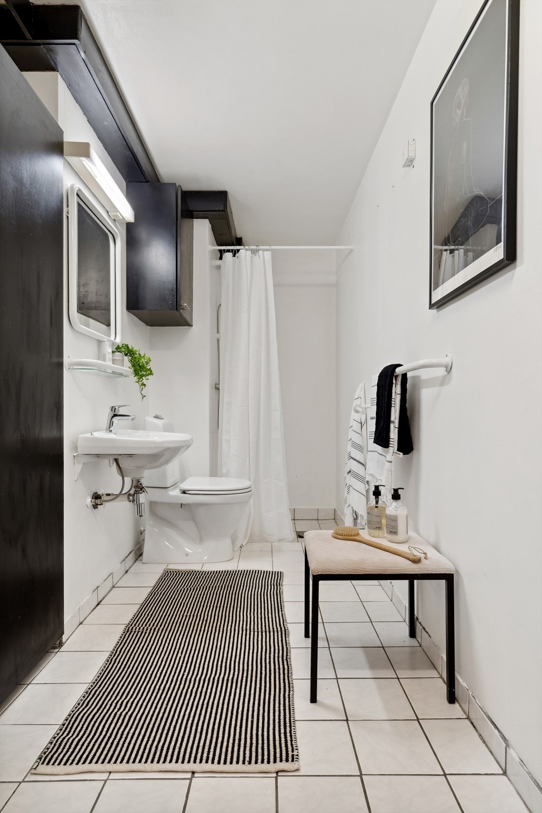 Badet i boligen er flislagt og består av enkel innredning Galleribilde