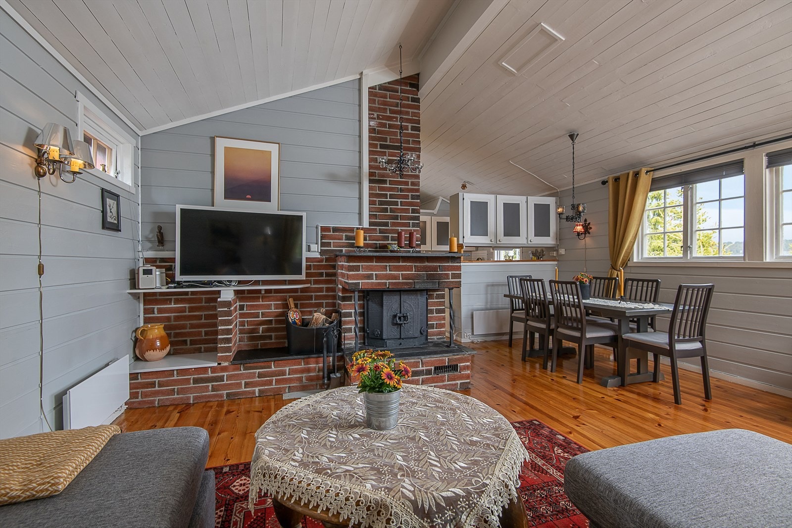 Stuen er tradisjonelt innredet med lakkerte tregulv, malt panel på vegger og tak. Galleribilde