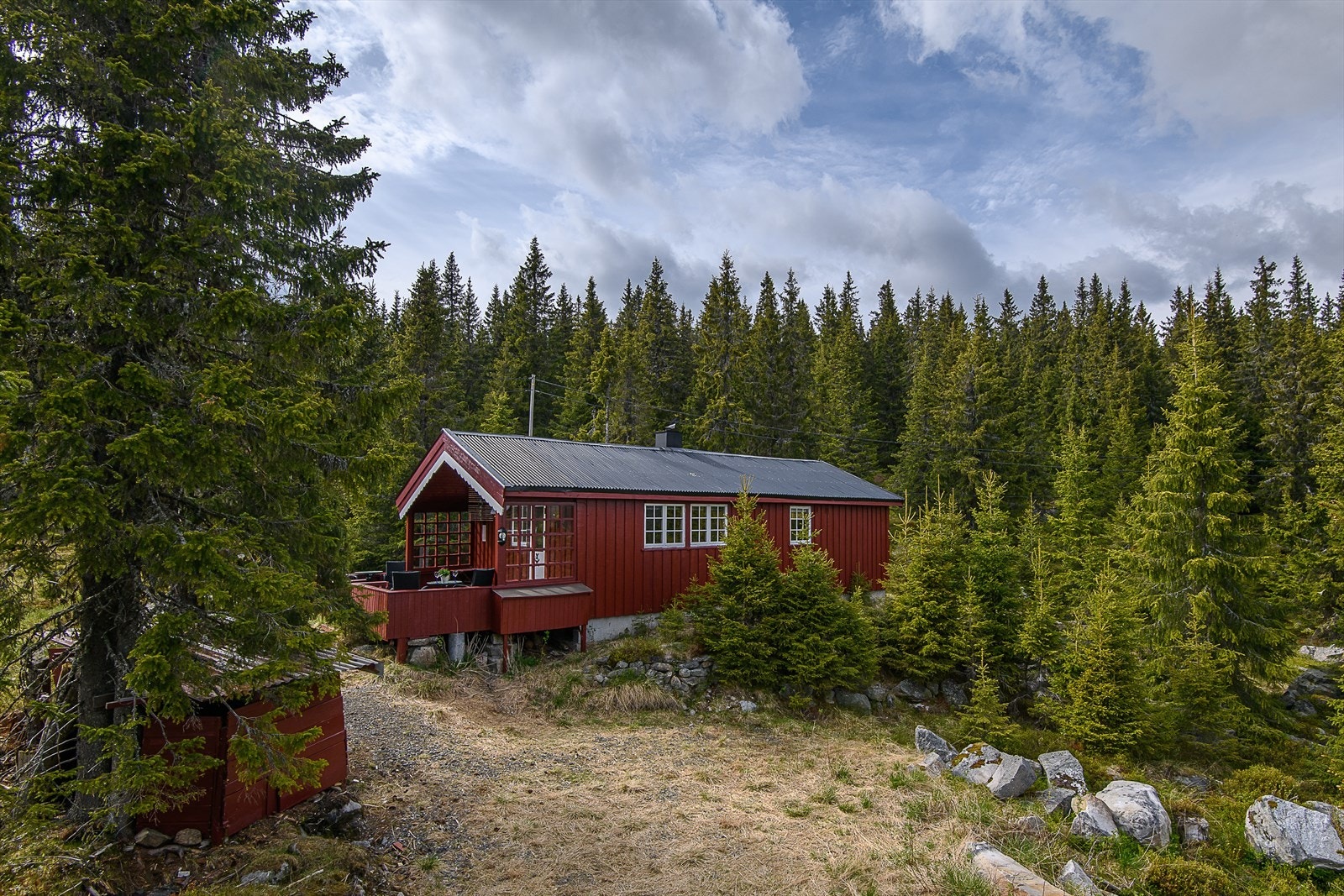 Eiendommen har kjørevei helt frem til hytteveggen på sommerstid. Galleribilde