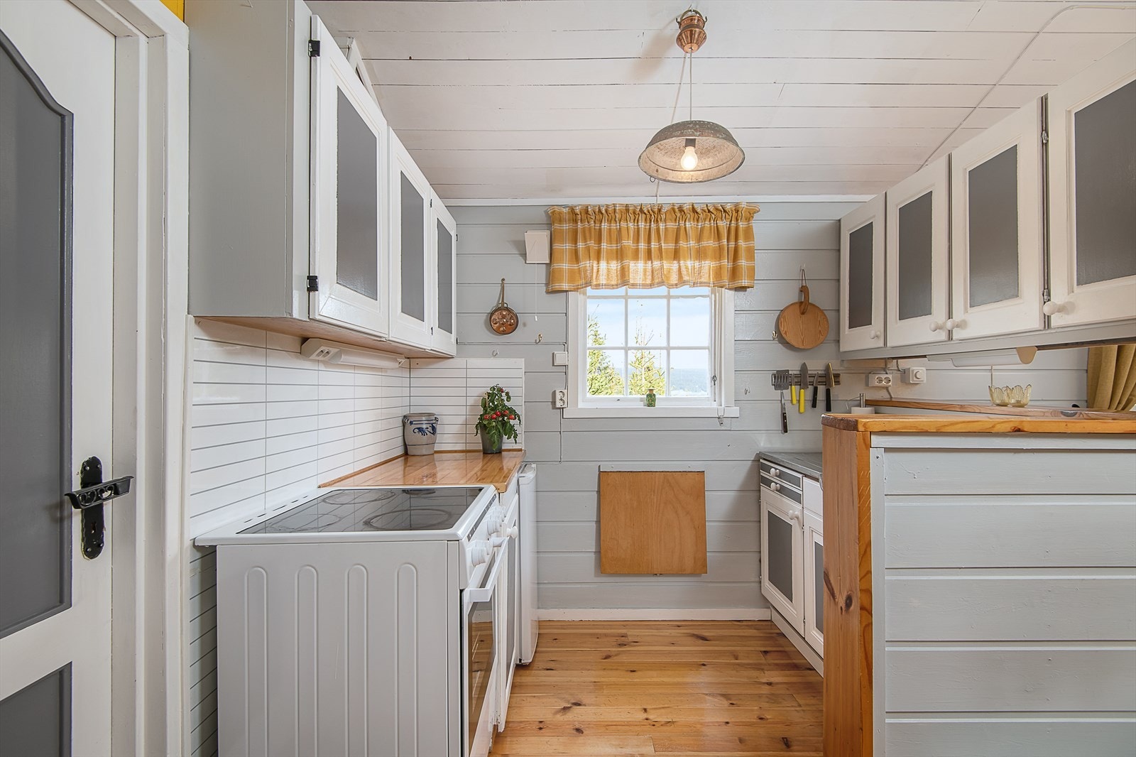 Kjøkkenet ligger åpent til stuen og har malte, profilerte trefronter som passer til rommets overflater. Galleribilde