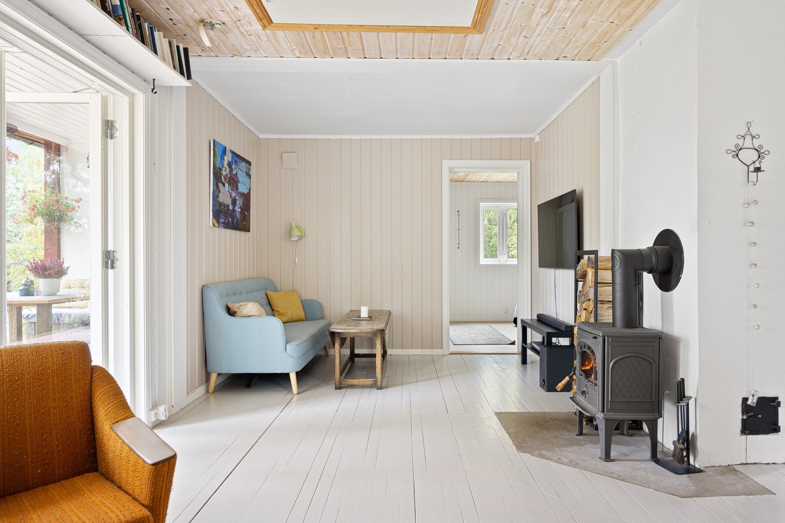 Stuen har peisovn, mye naturlig lys og utgang til terrasse. Galleribilde