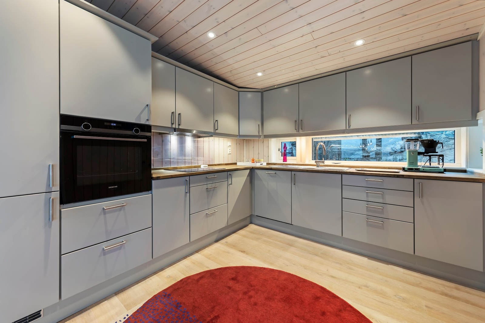 Pent kjøkken med mye skapplass og integrerte hvitevarer fra Siemens Galleribilde