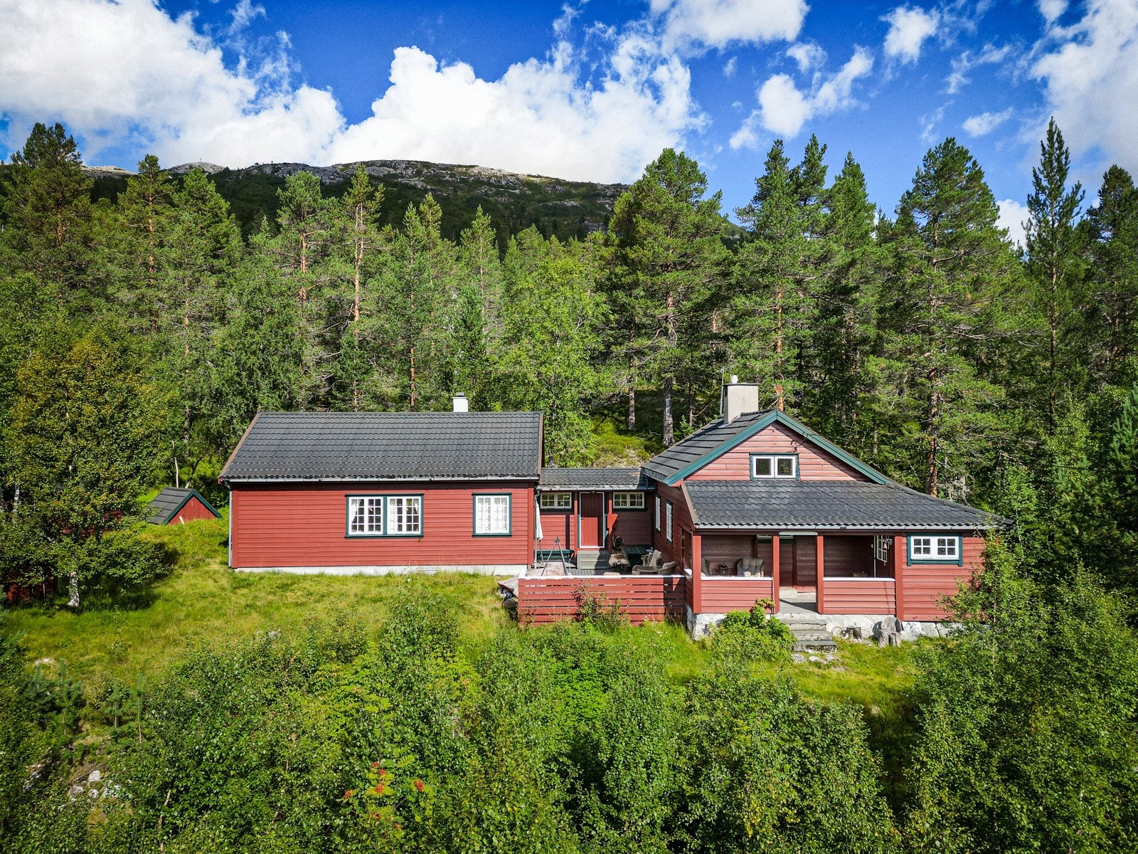Stor familiehytte med tilbygg til venstre og eldre del til høyre. Galleribilde