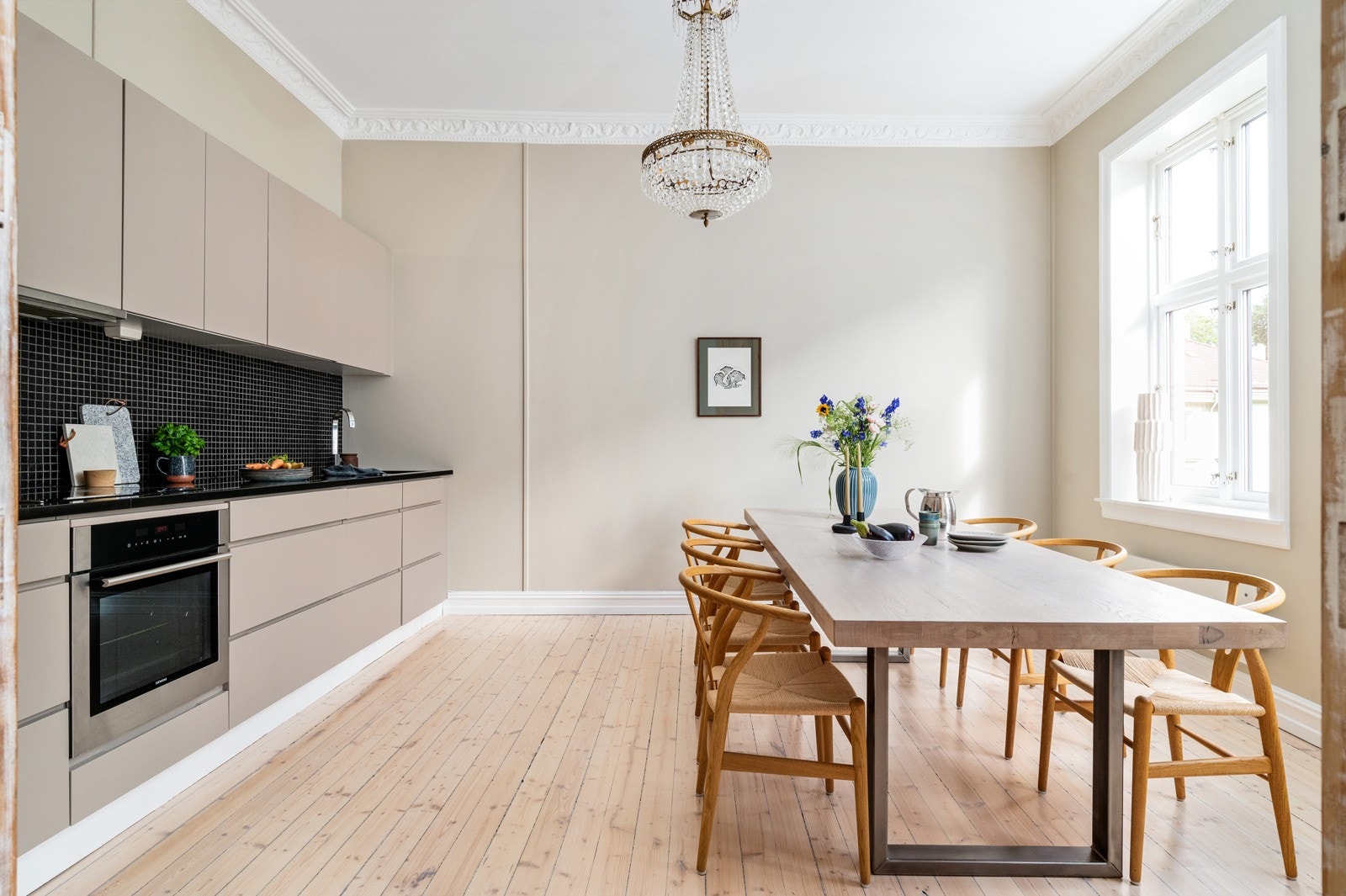 Kjøkkenet kler leiligheten godt og har selv plass til et langbord foran krysspostvinduene. Galleribilde