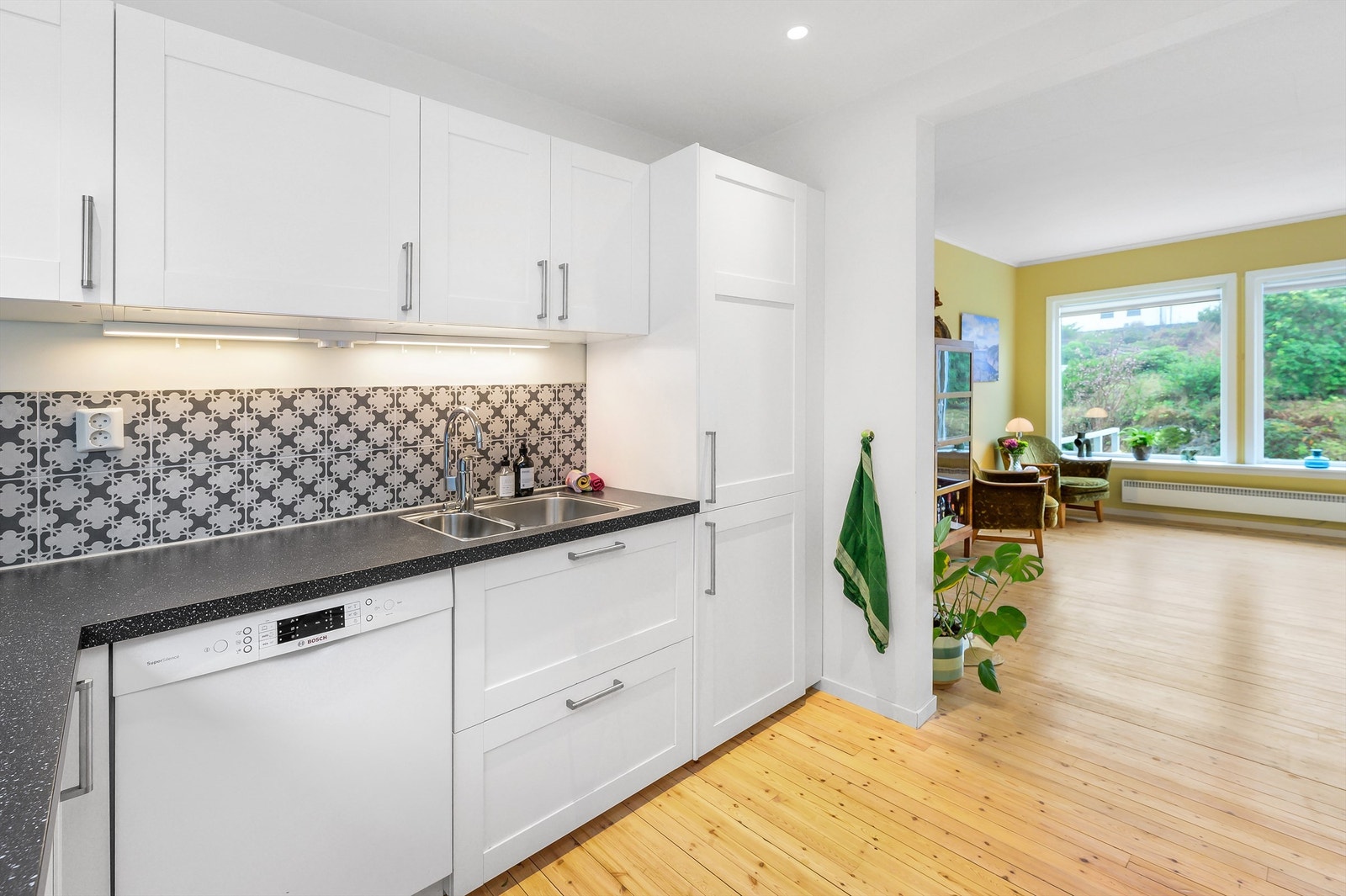 Over benkeplaten i våtsonen er det dekorative fliser, og det er lys under overskap. Galleribilde