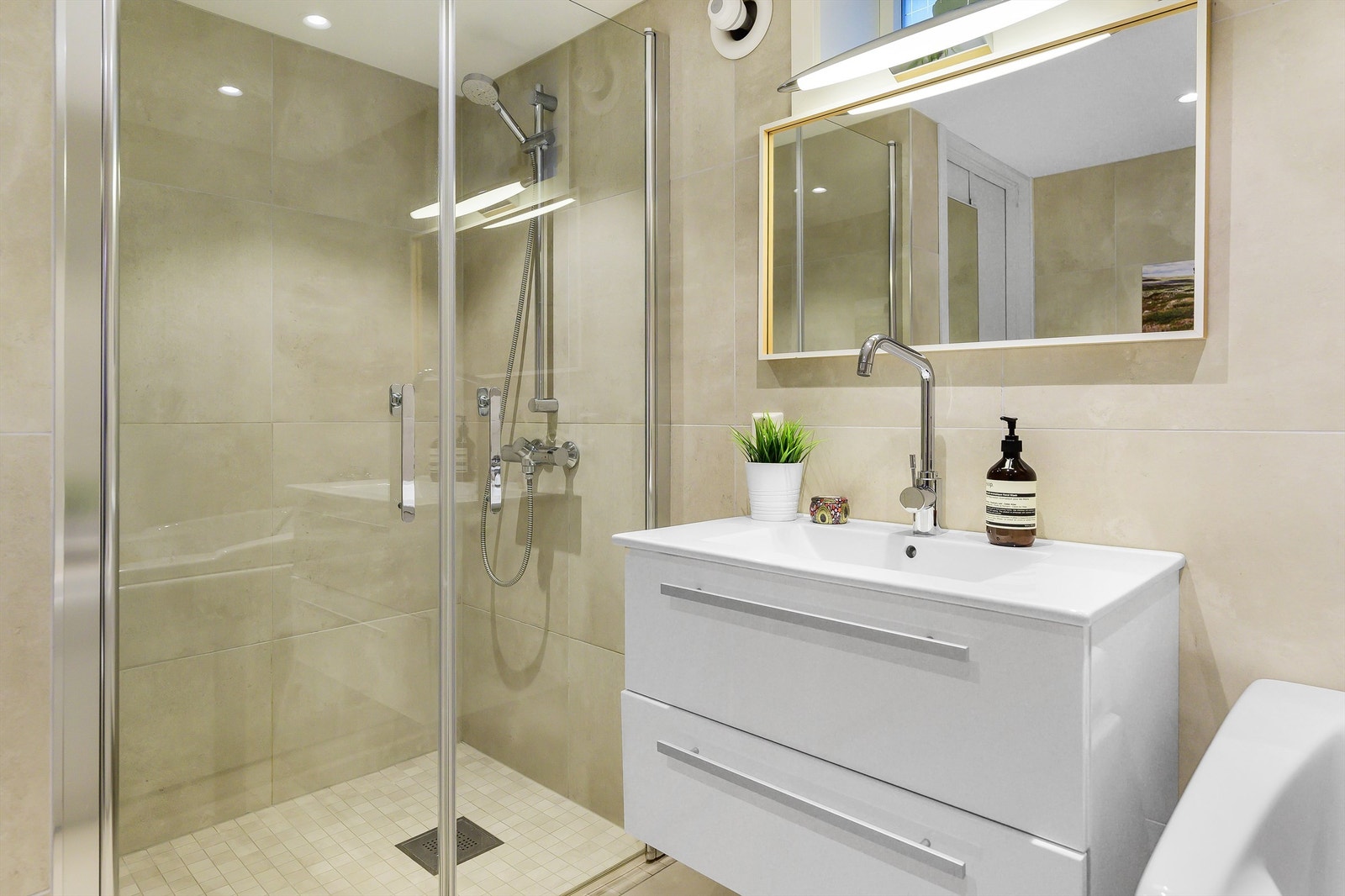 Rommet er av god størrelse og rikt utstyrt med en pen innredning med underskuffer, heldekkende servant, samt speil med lys over denne. Galleribilde