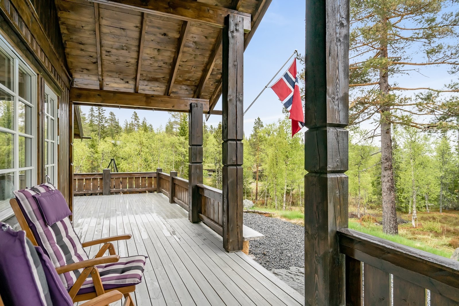 Delvis overdekket veranda med utgang fra stue og adkomst fra terreng Galleribilde